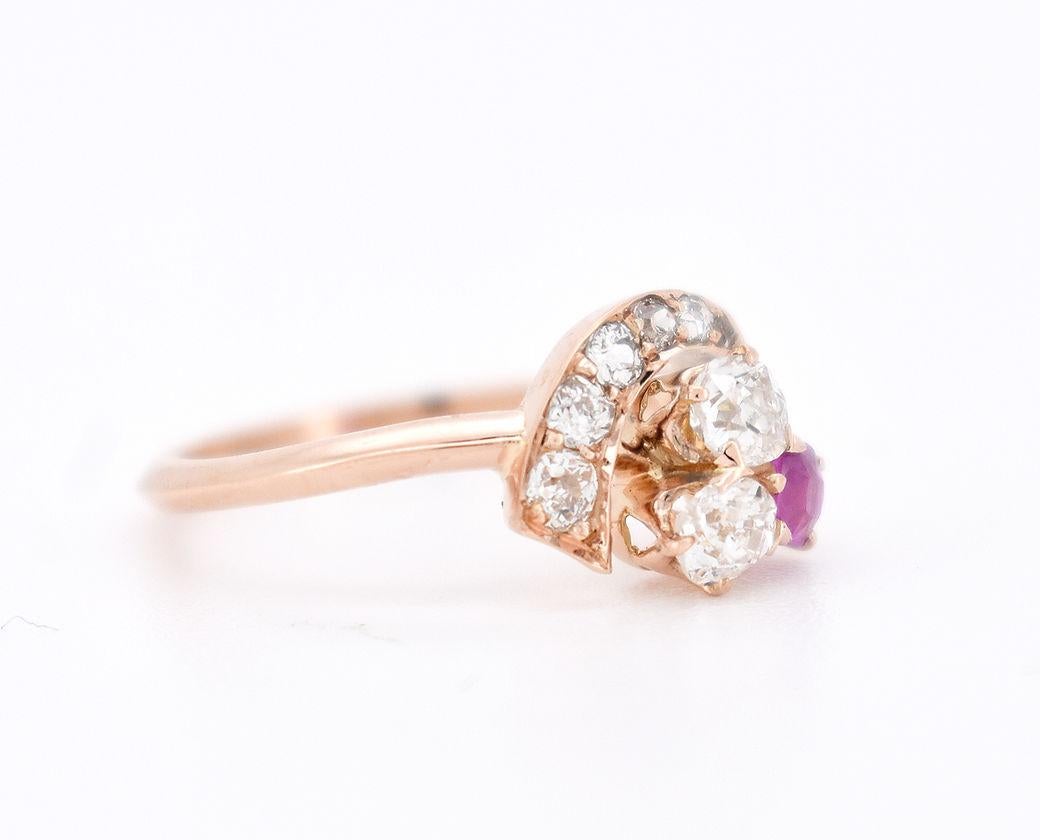 This antique trilogy ring, dating back to the Belle Époque era (circa 1900), is crafted in 18-carat white gold (750/1000). Designed in the shape of a clover, it is adorned with three main gemstones: two old-cut diamonds of approximately 0.10 carats