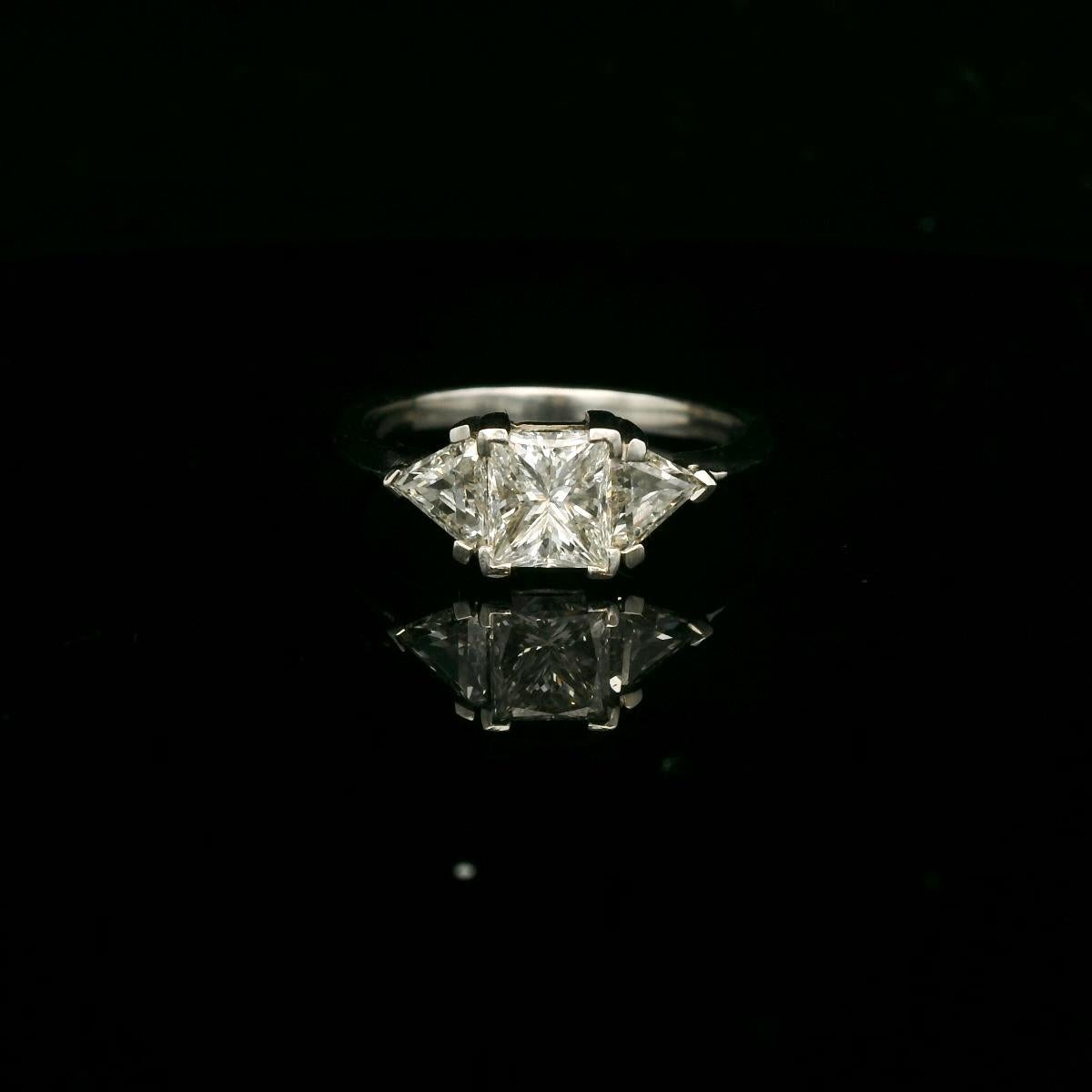 Trilogie diamond ring.

The ring is set with a princess cut diamond of approximately 1 Carat ( estimated H color - Vs clarity) and 2 triangle shape diamonds for a total of approximately 0.60 Carats ( estimated H color - Vs clarity).

Total weight of