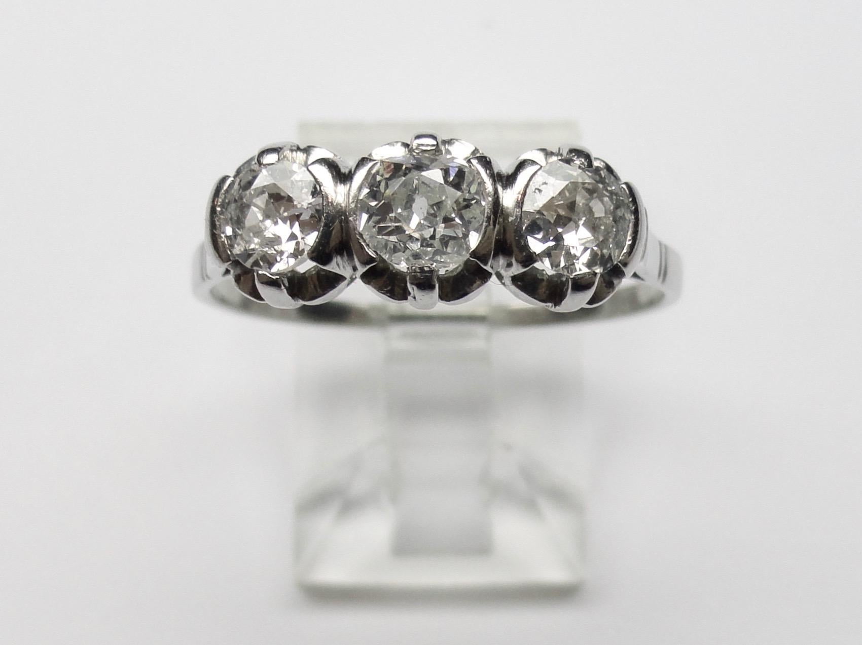 Bague trilogie classique avec un diamant central de taille coussin et deux diamants de taille Old Euro sur les côtés, estimés à 0,80ct au total. Serti en platine des années 1940. 
