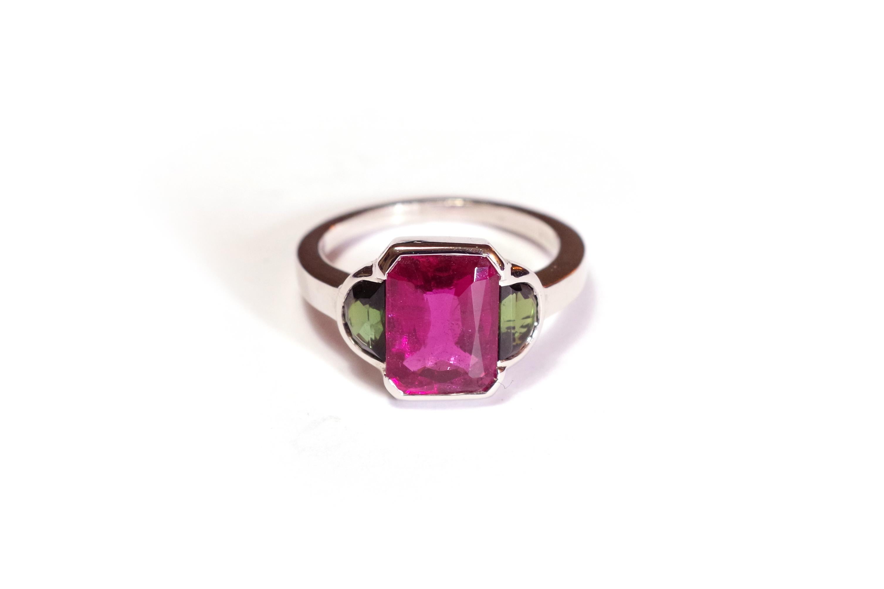 Trilogy tourmaline ring in white gold 18 karats. Ring centred with an important pink tourmaline, also called rubellite, rectangular fancy cut. The rubellite has a beautiful raspberry-pink colour with a dark red undertone. The gem is framed by two