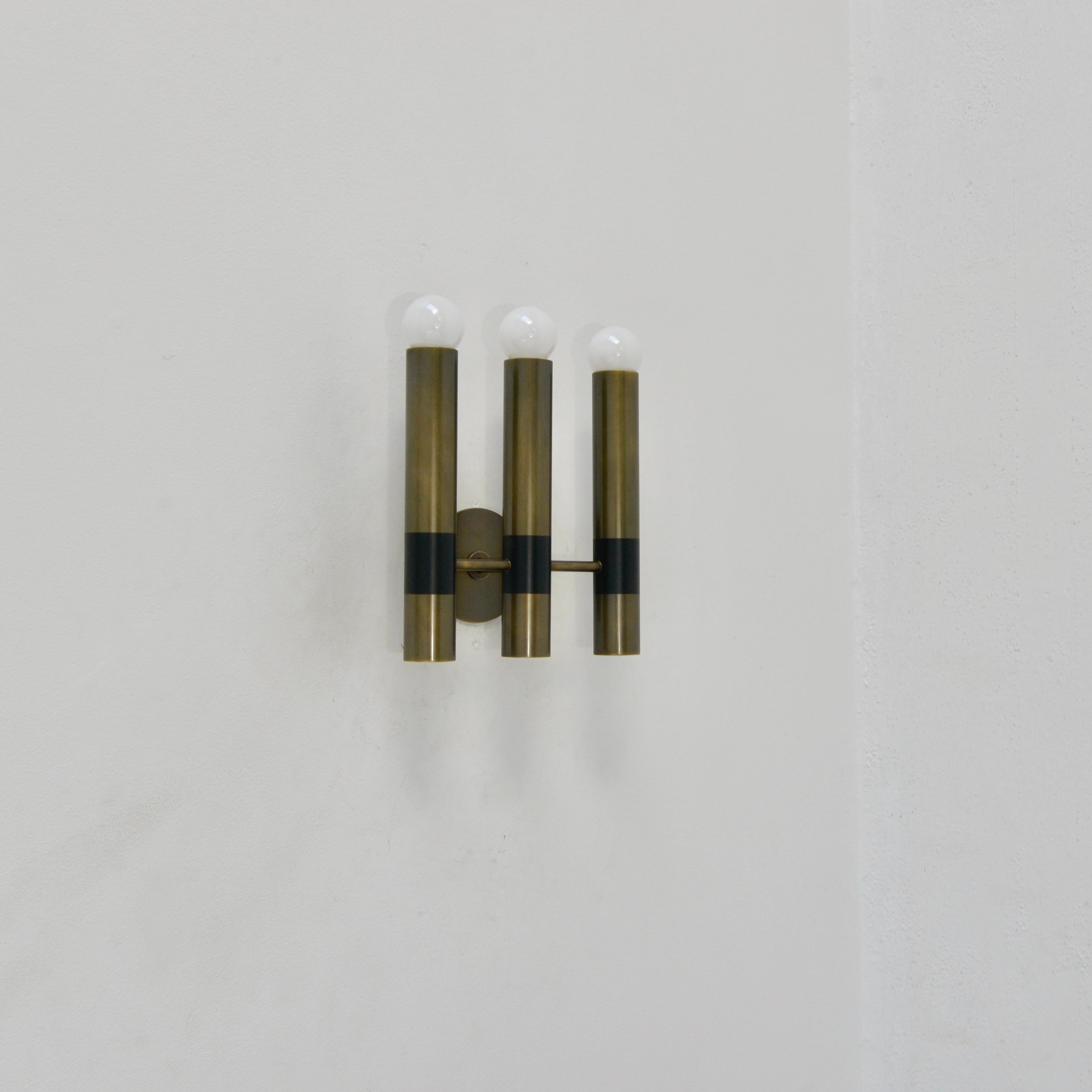 Elegant tubular TriLU wall sconce by Lumfardo Luminaires is made to order. This trident sconce has 3 tubular light sources in brass, aluminum and steel. Wired for the US with (3) E-12 candelabra based sockets. Lightbulbs included with order. 10-12