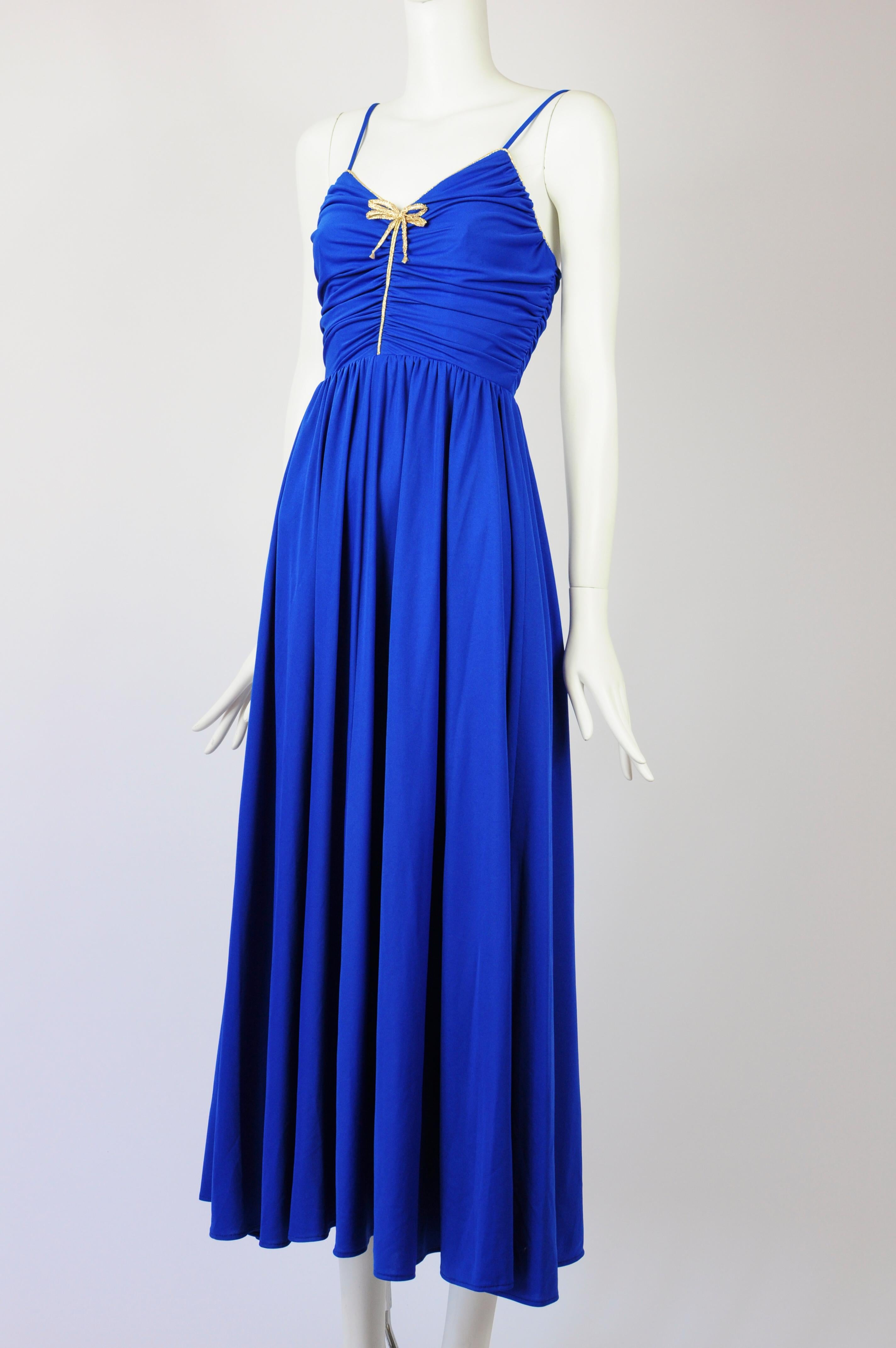 A Trina Lewis & Marjon Couture af Baker Sportswear London vintage dress in royal blue with gold piping and bow details. The dress bodice is beautifully pleated and the royal blue fabric gathers in front where the gold piping detail and gold bow are