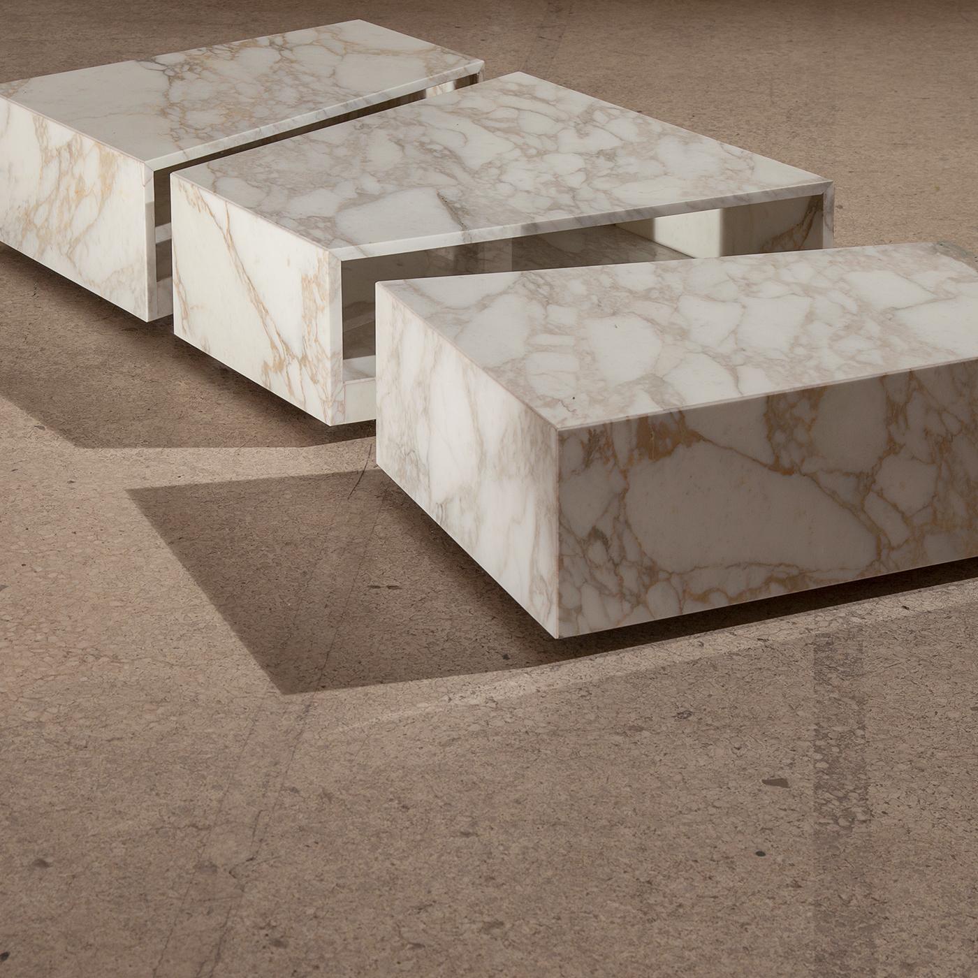 This majestic coffee table is not only a striking object of functional decor but doubles as a storage unit. The bold profile is composed of three pieces equipped with rollable wheels, made of white Calacatta marble, showcasing its singular thick