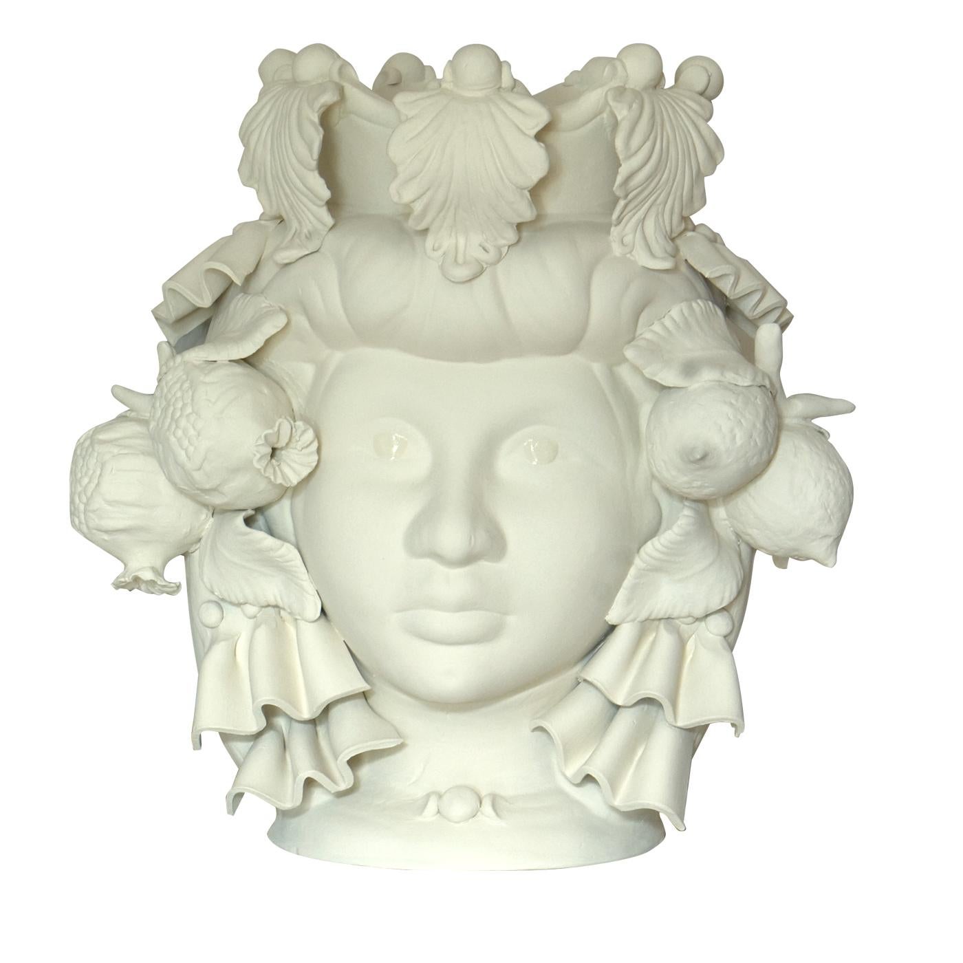 Ce vase anthropomorphe est entièrement fabriqué à la main et peint dans une teinte monochrome ivoire mat, riche en pigments naturels et en liants résineux qui donnent une profondeur de couleur intense. Seuls les yeux sont glacés pour qu'ils