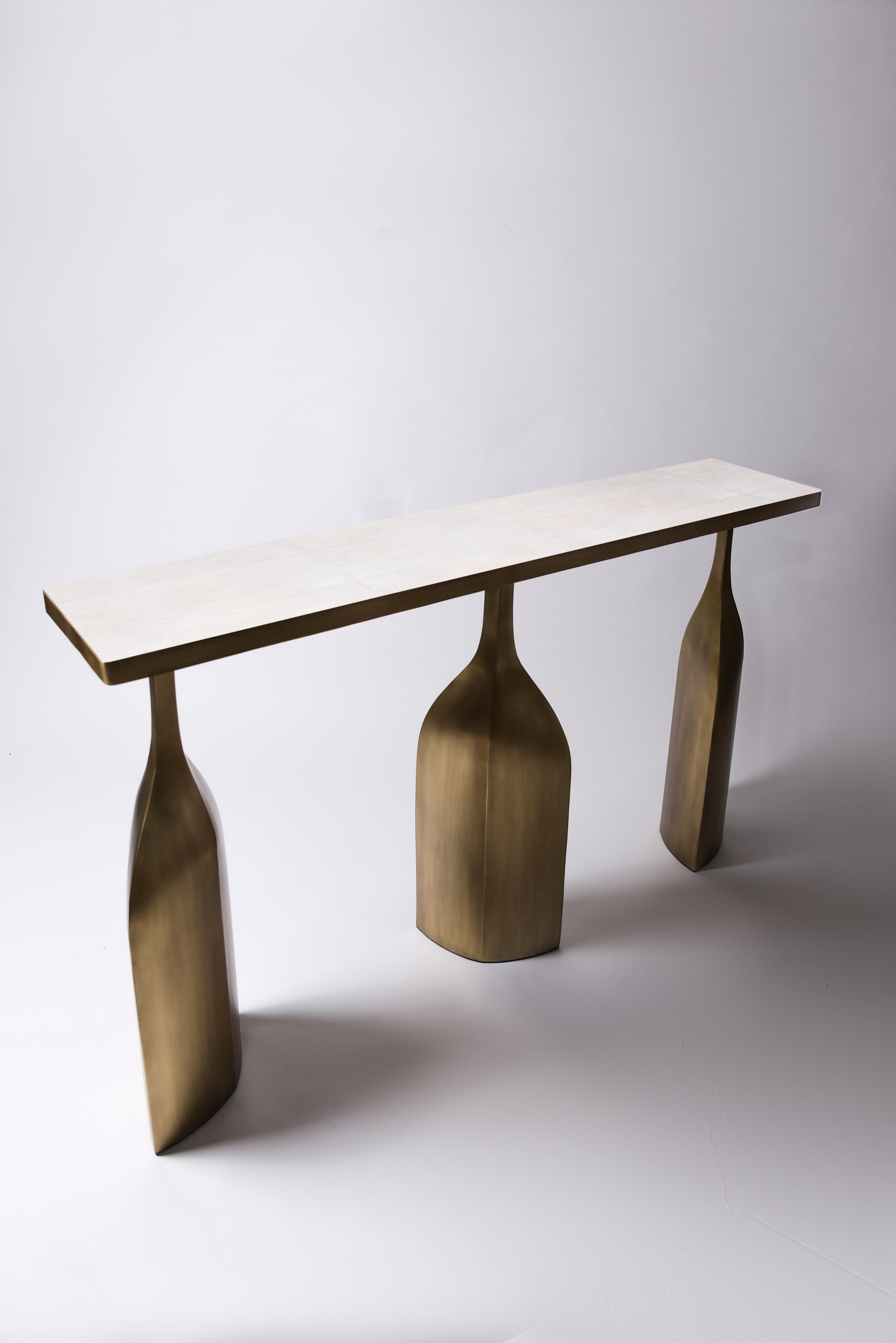 The trinity console is bold and exquisite in design. The top is inlaid in cream shagreen and sits on three stunning bronze-patina sculptural legs. The top is available in other finishes, see images at end of slide. This piece is designed by Kifu