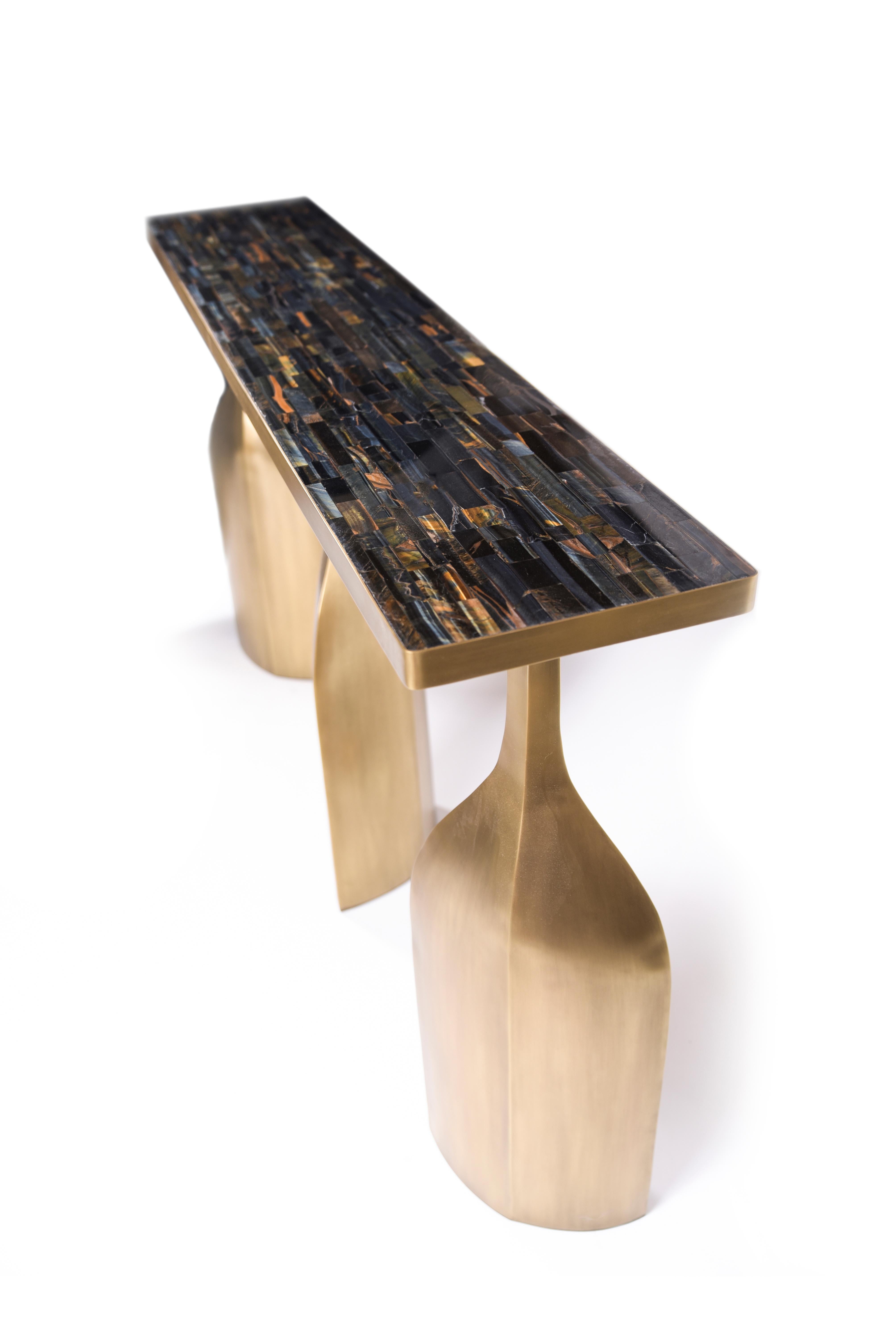 The Trinity console is bold and exquisite in design. The top is inlaid with the dreamy semi-precious stone: tiger eye blue. The stone features incredible natural details with its mixture of blue, black and gold hues. The top sits on three stunning