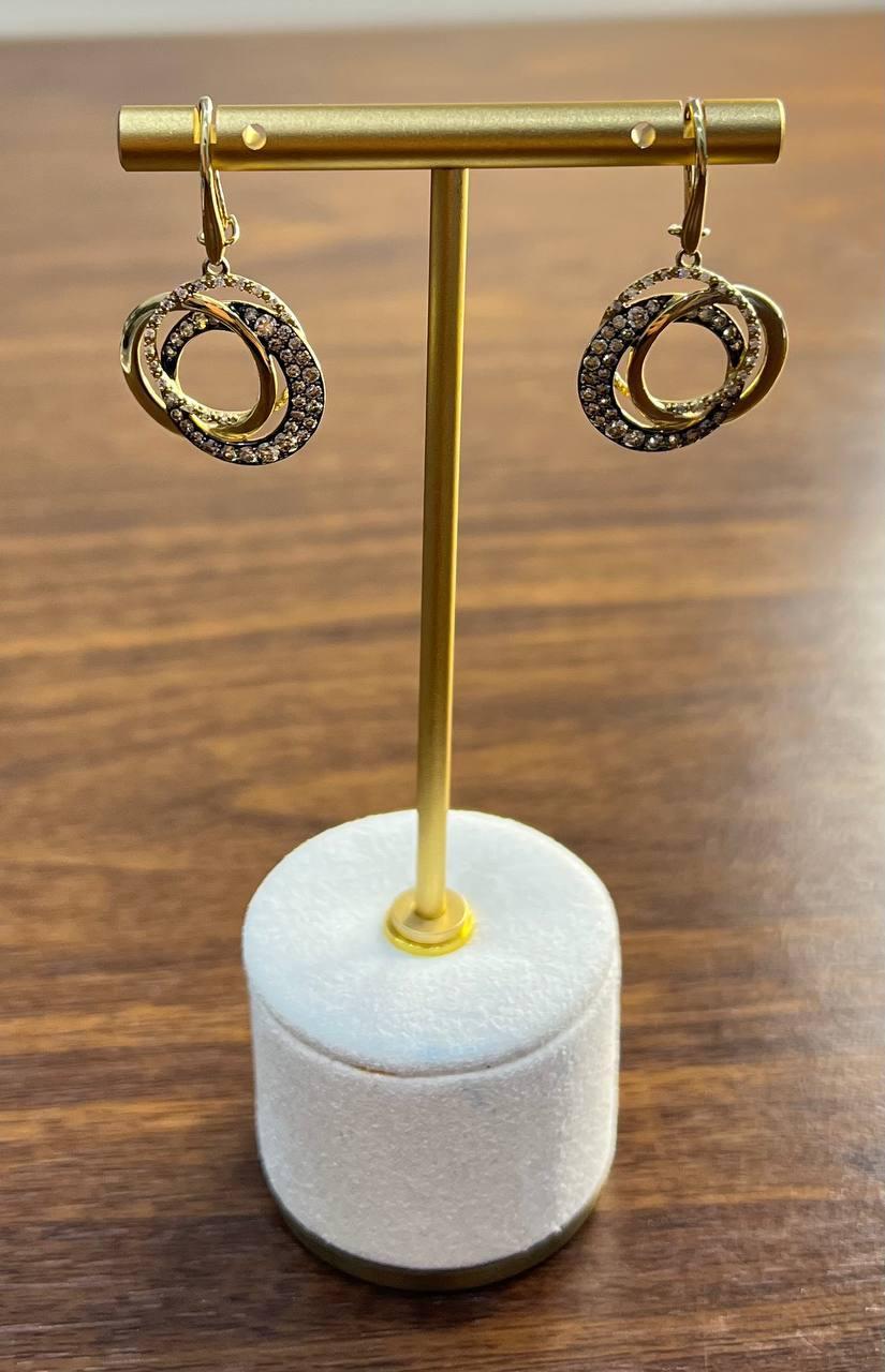 Ces boucles d'oreilles sophistiquées sont fabriquées en or 14K.
Chaque boucle d'oreille présente un design de boucle entrelacée, ornée de diamants brun champagne qui ajoutent une touche d'éclat.
Les boucles sont gracieusement suspendues à un simple