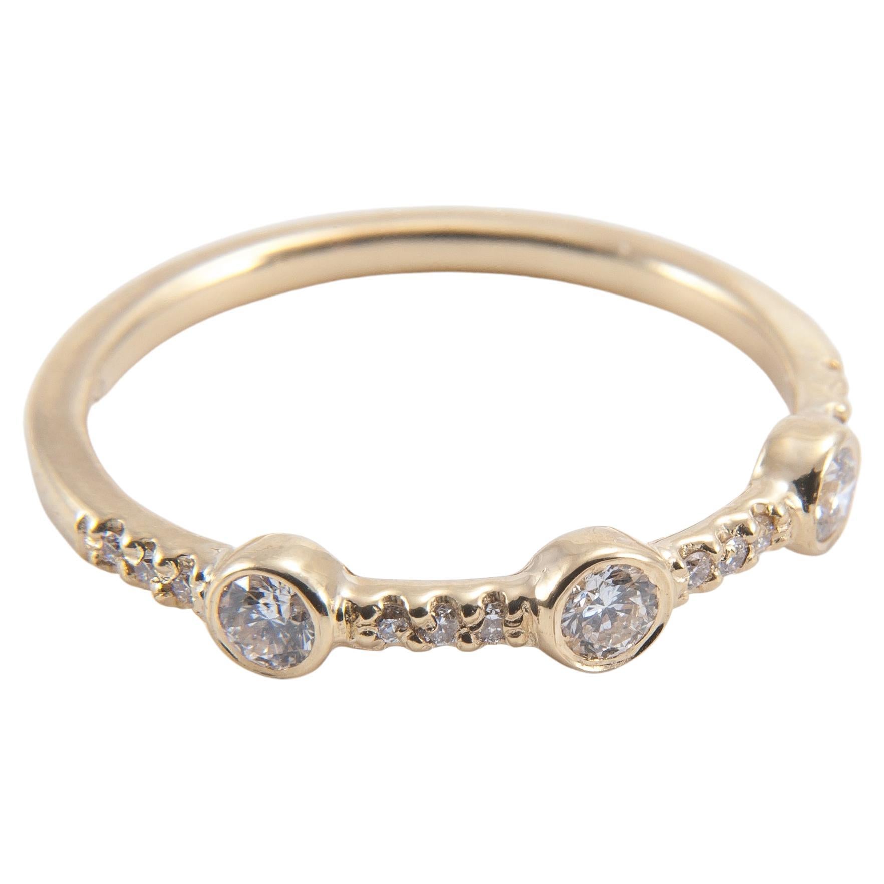 This classic pave-set diamond band is punctuated by three brilliant cut white diamonds. Wear alone or stack with our other gem set rings.

18K yellow gold band featuring three bezel set 0.10” white diamonds between pave set white diamonds.