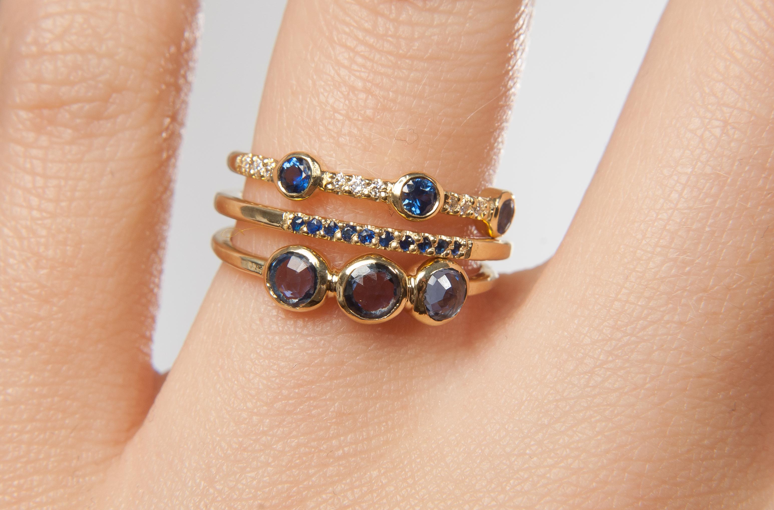 A trio of deep blue sapphires is enhanced with pavé set white diamonds on this delicate gold band.

18K yellow gold band featuring three bezel set 0.10” blue sapphires between pavé white diamonds.