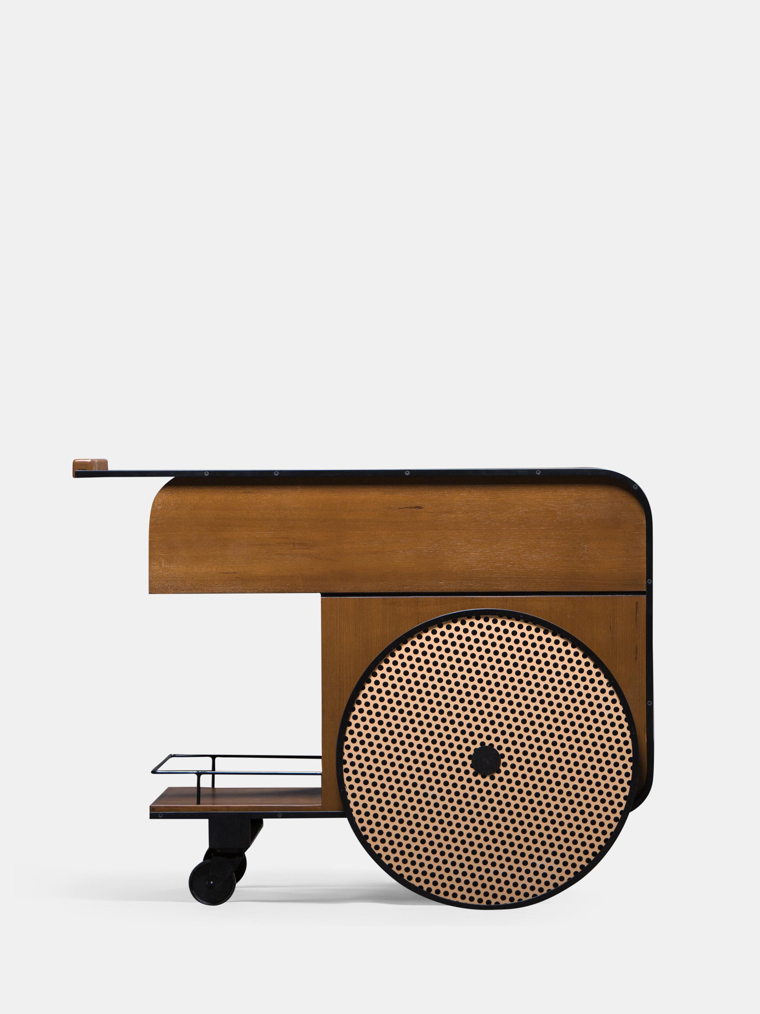 Chariot de bar en teck Trink de Kann Design
Dimensions : D 54 x L 100 x H 75 cm.
MATERIAL : Cadre en acier, bois massif de teck, placage de bois, roue en caoutchouc, aluminium.

Avec le chariot de bar Trink, les deux designers Karl Chucri et Rami