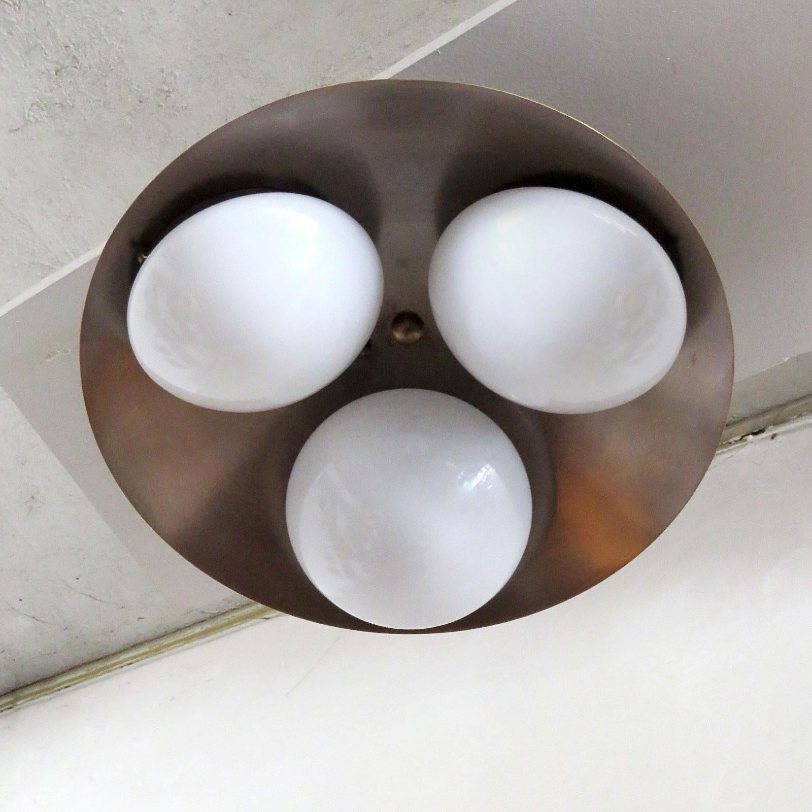 Elegant Trinova wall or ceiling light designed by Gallery L7, handcrafted and finished in Los Angeles from American brass, with three opaline glass shades on an aged raw brass disc. Three E12 sockets per fixture, max. wattage 60w each or 3-7w LED