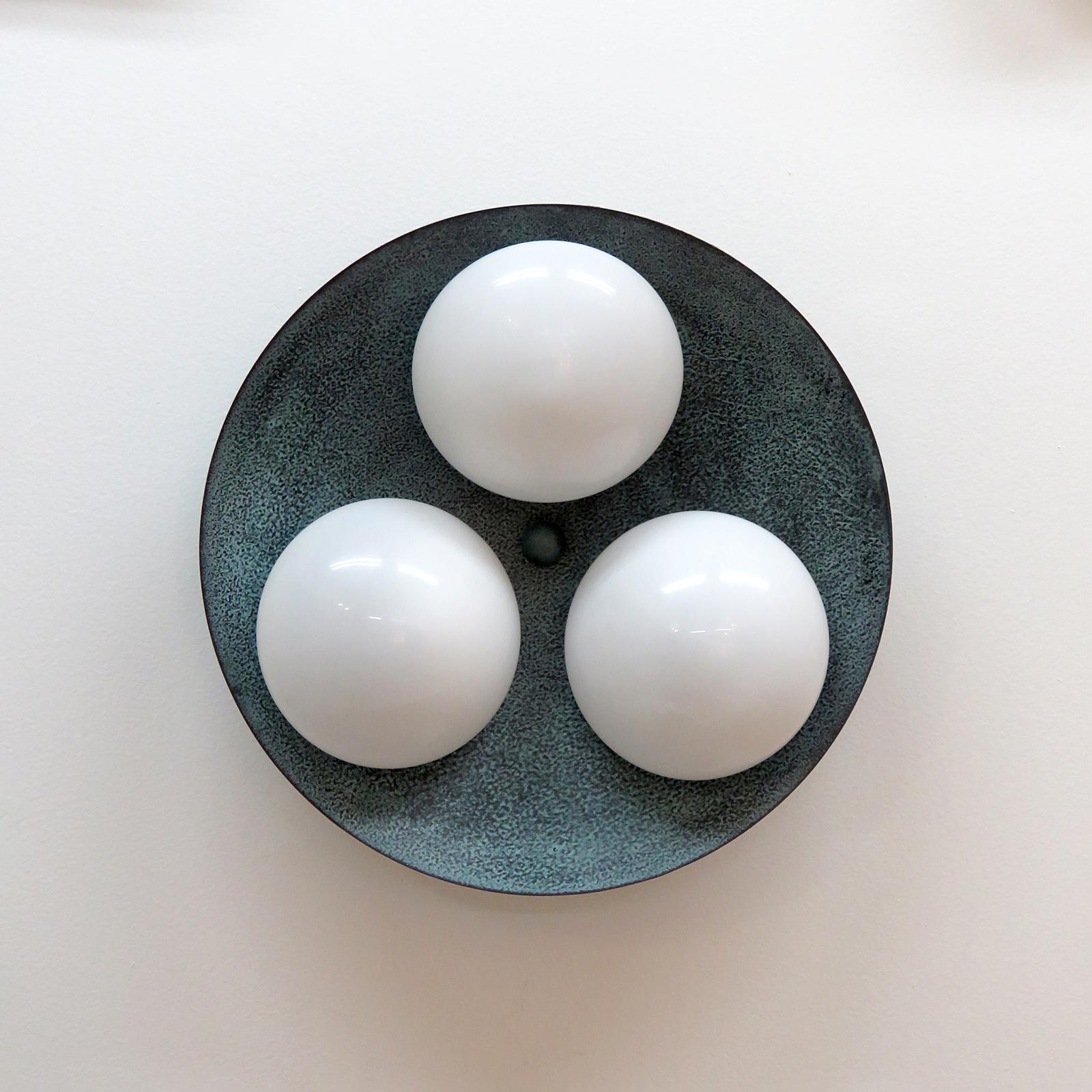 Elegant Trinova outdoor wall/ceiling light designed by Gallery L7, handcrafted and finished in Los Angeles from American brass, with three opaline glass shades on a verde gris patina brass disc. Available with gloss or satin glass shade. Due to the