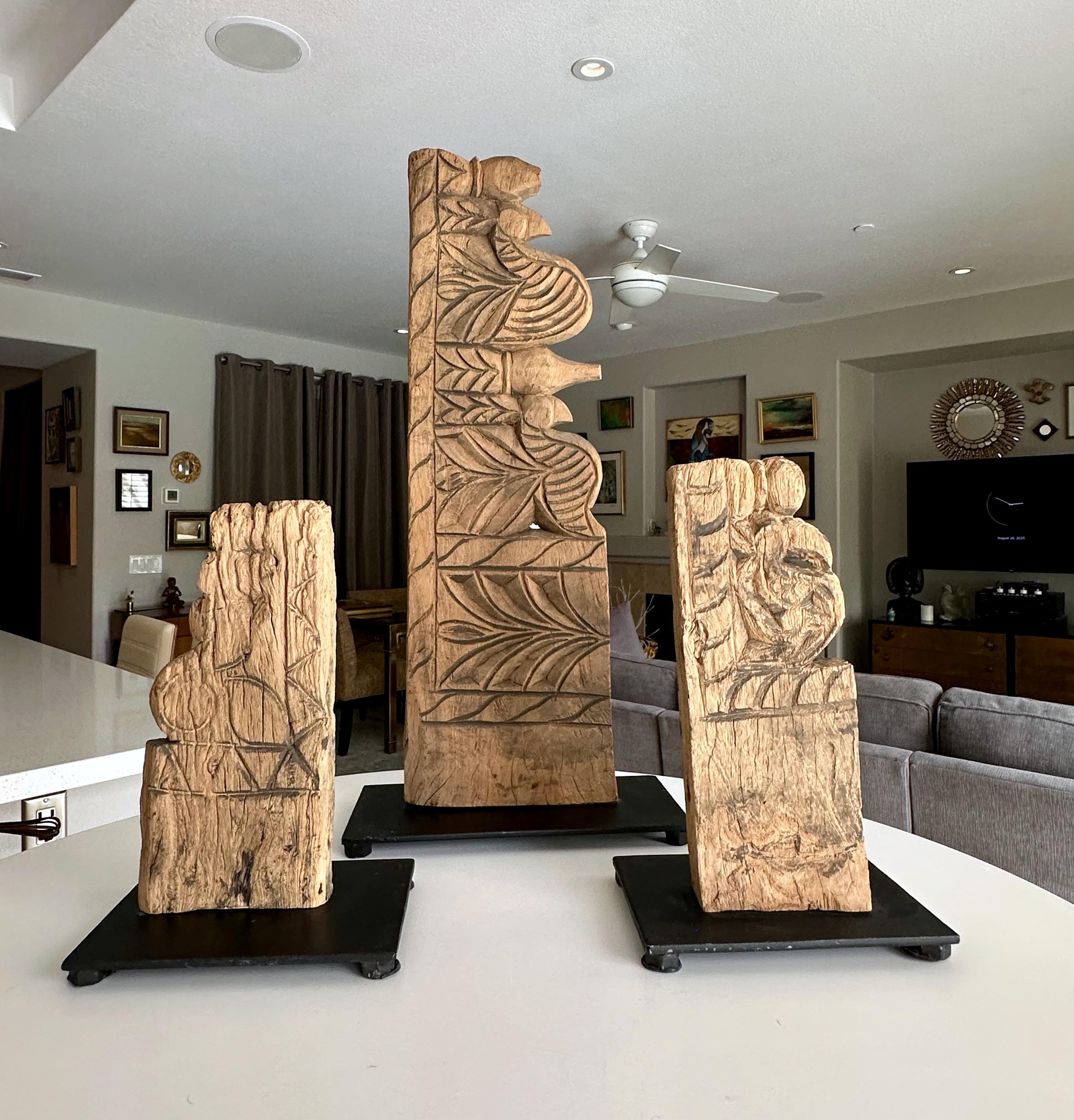 Set of three decorative 19th century Asian architectural carved wood fragments each mounted on custom black metal stands. Possibly temple fragments from Thailand. Priced as group. Various sizes:
25