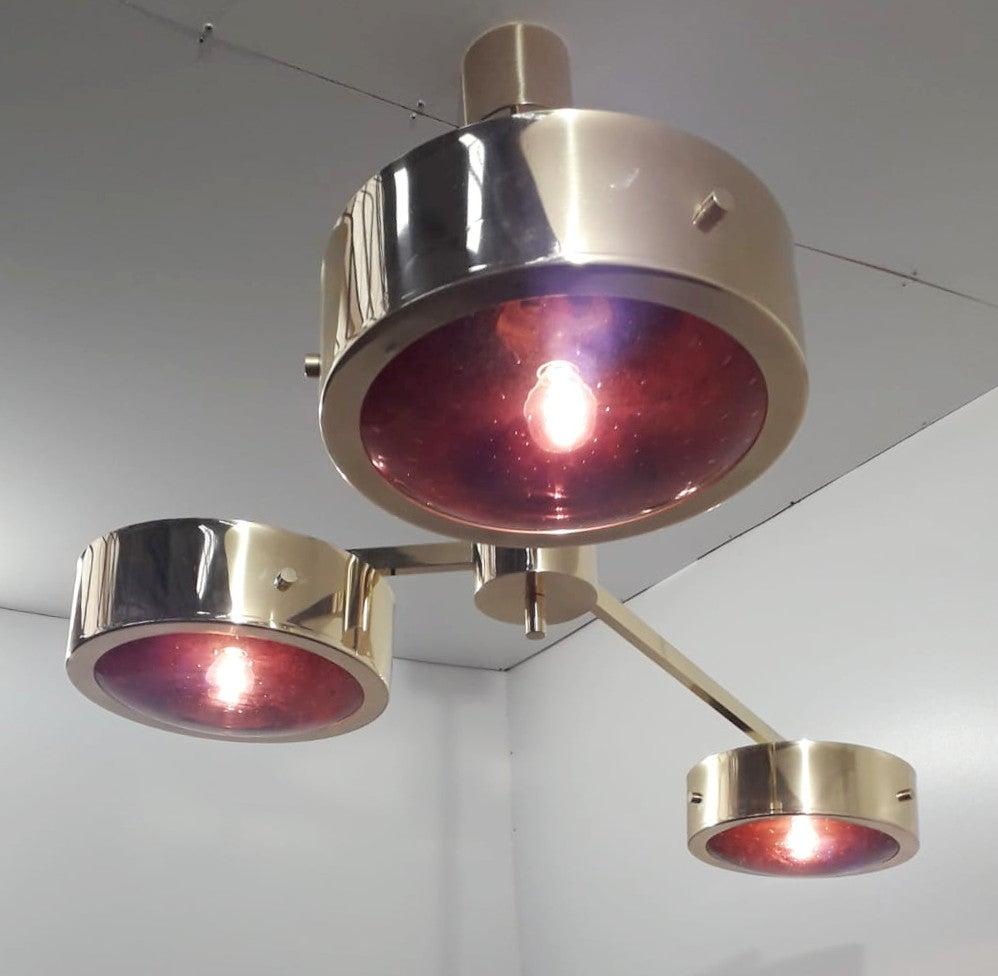 Pendentif moderne italien avec trois abat-jour en verre de Murano améthyste soigneusement soufflé à la main avec des bulles à l'intérieur du verre selon la technique Bollicine, entouré de bandes de bordure en laiton poli chic et monté sur un cadre