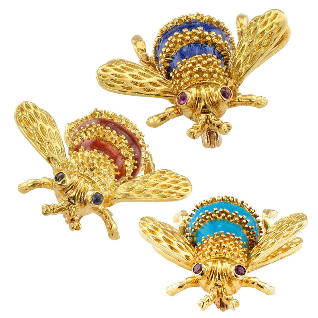 Trio of enameled bee brooches with rubies and sapphires on 18-karat gold circa 1960s. These delightful honeybees feature banded abdomens decorated with granulation enameled in between with royal blue, ochre and turquoise color, respectively. The