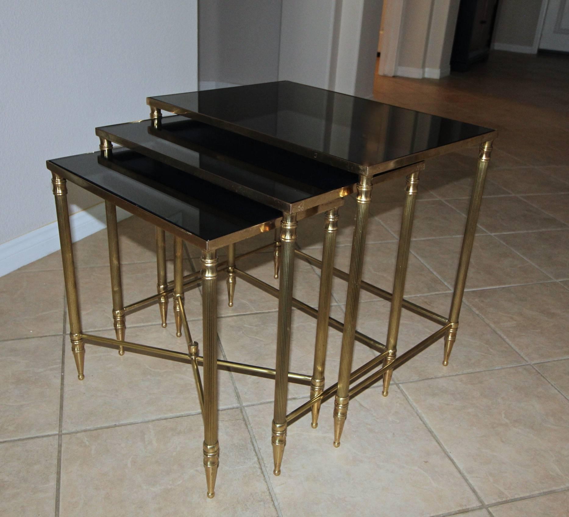 Trio of French brass nesting tables with newer dark graphite color mirrored glass inset tops.
Measures: Table #1 - 22