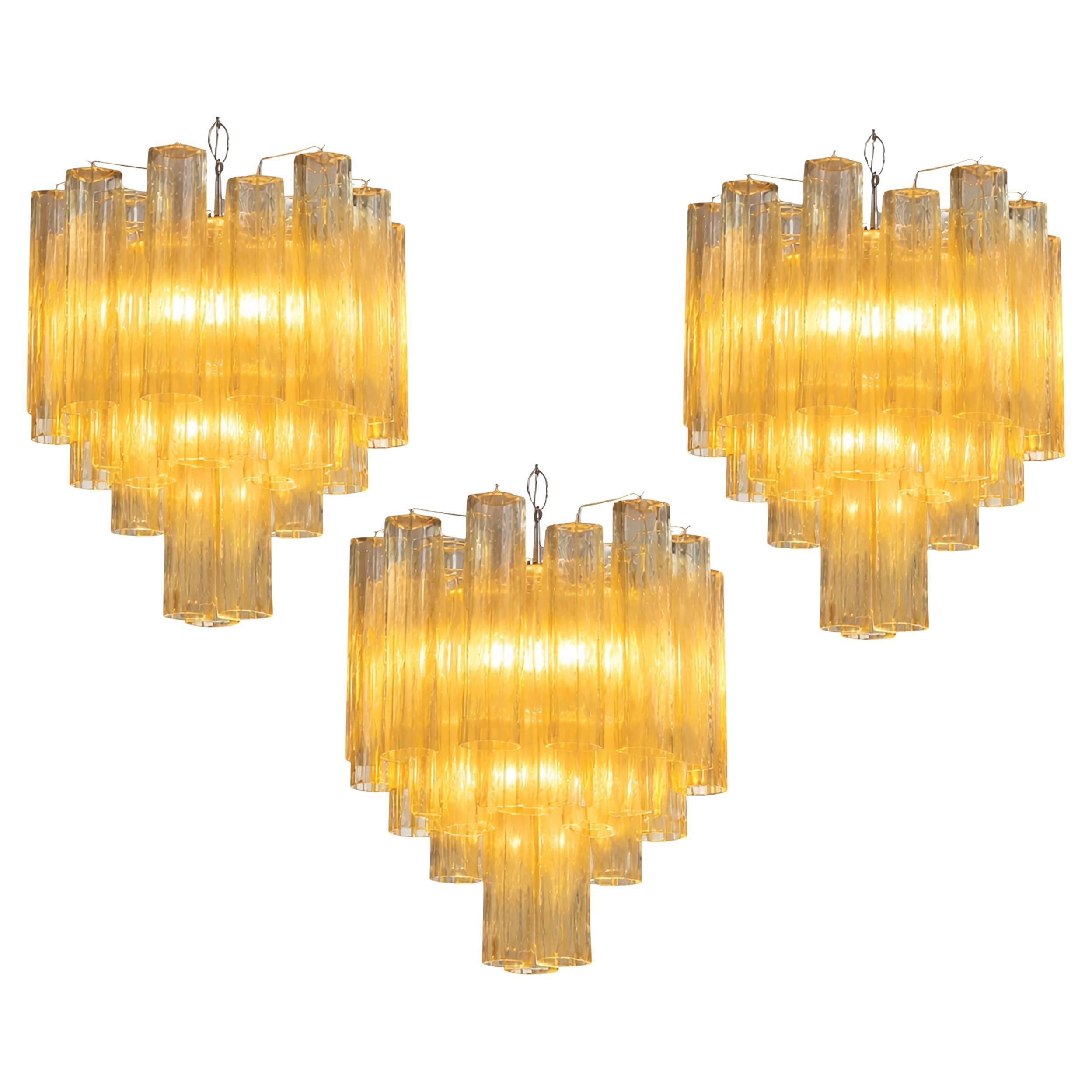 Trio di lampadari a tubo in vetro dorato, Murano, anni 
70