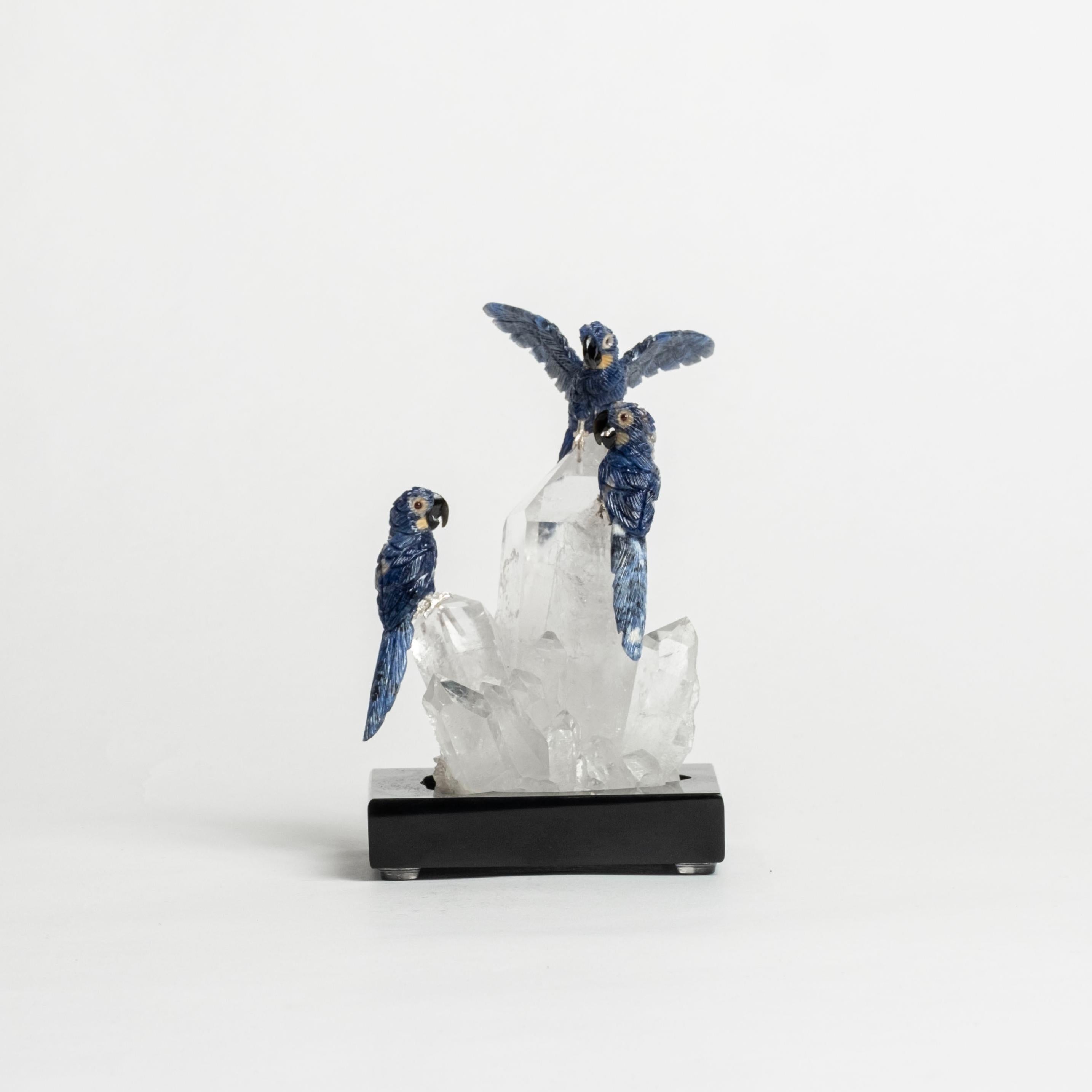 Trio of hand-carved Lapis Lazuli parrots with rock quartz specimen on marble base. 