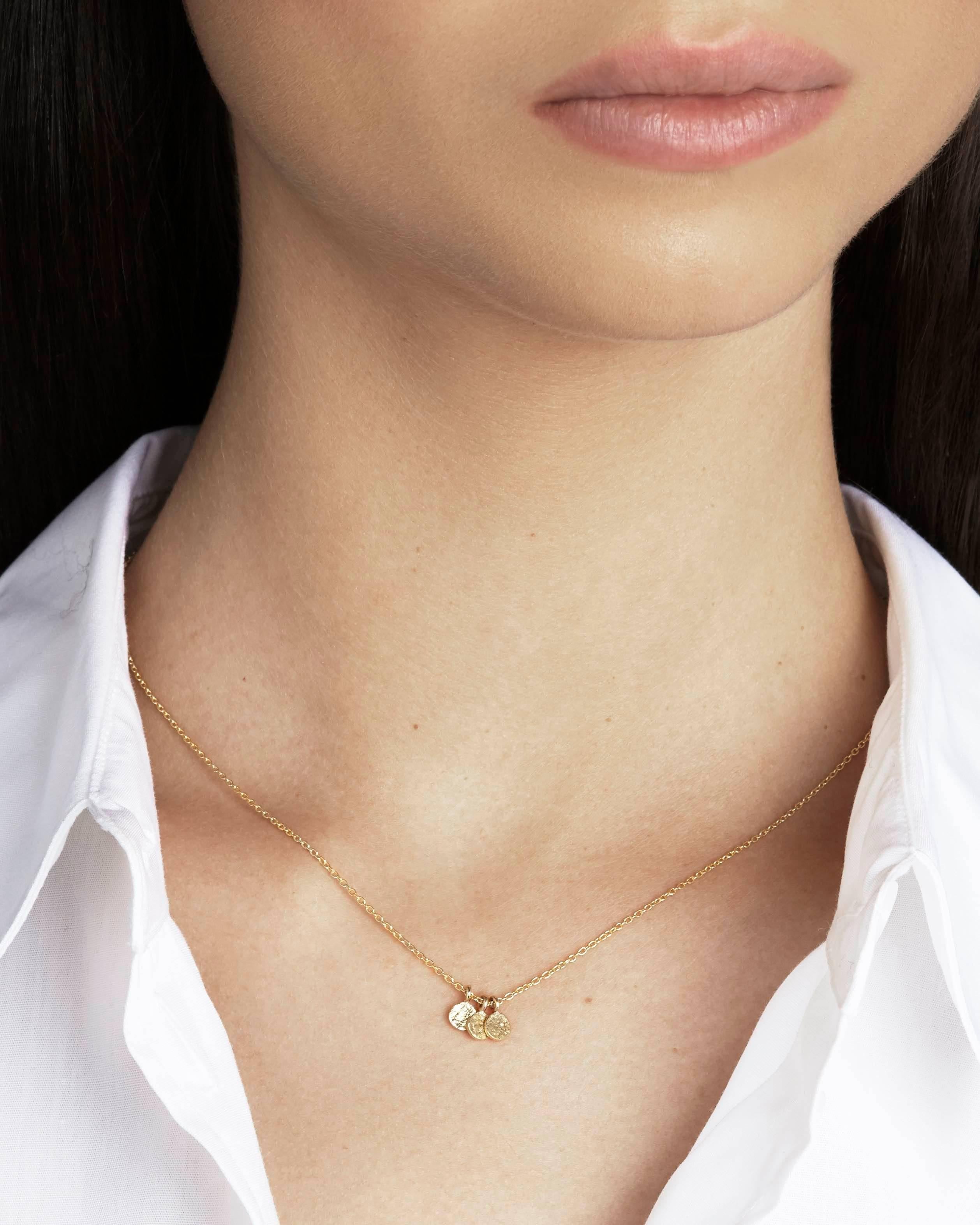 Featuring our signature Paper texture on three tiny disc pendants, the trio necklace is crafted in solid 18-carat yellow gold. The pendants are strung on a delicate 16-inch 18-carat gold chain.  The reverse of the pendants can be engraved with