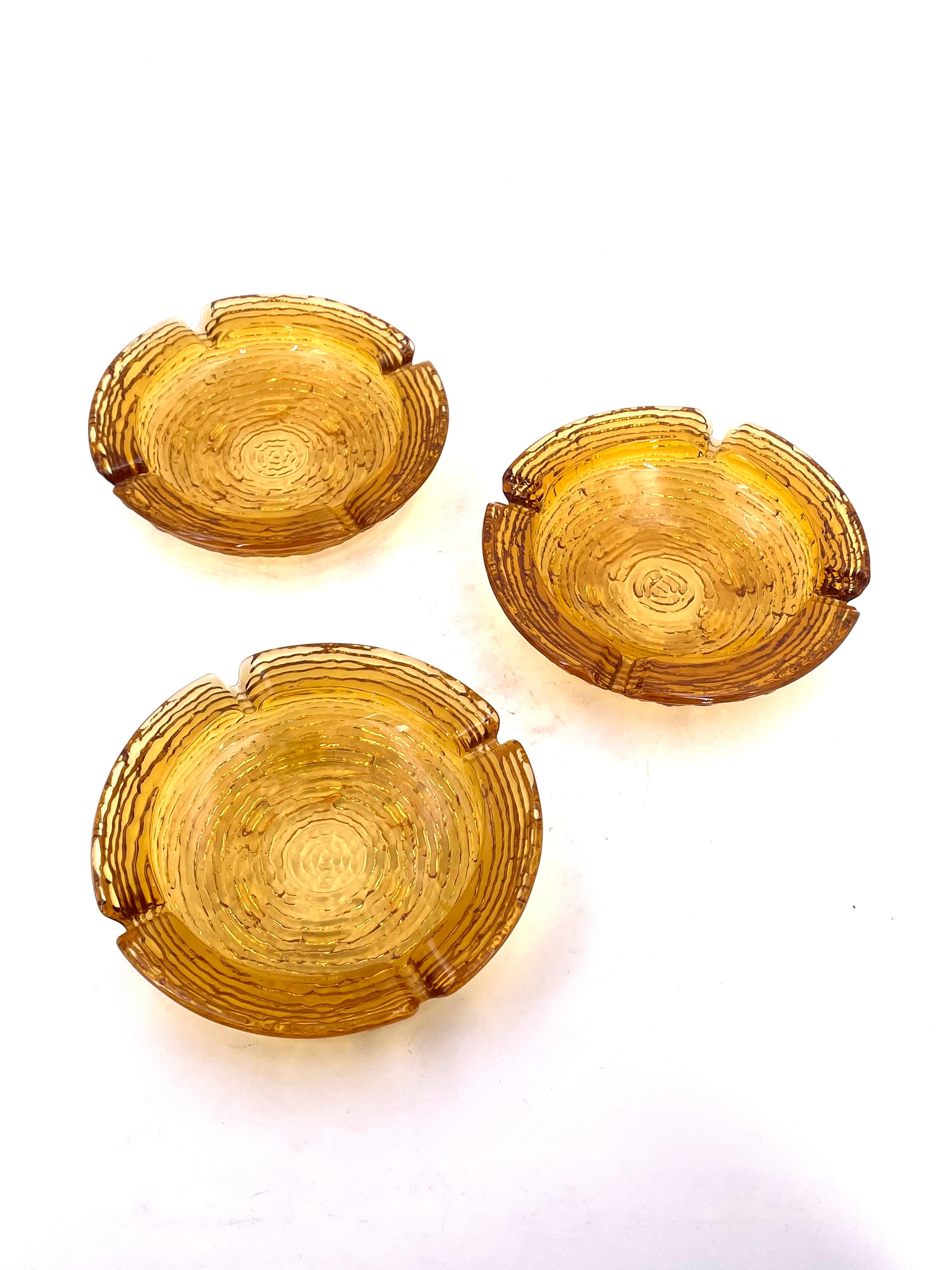 A beautiful trio of textured glass amber color ashtrays, excellent condition no chips or cracks. by Anchor Hocking.