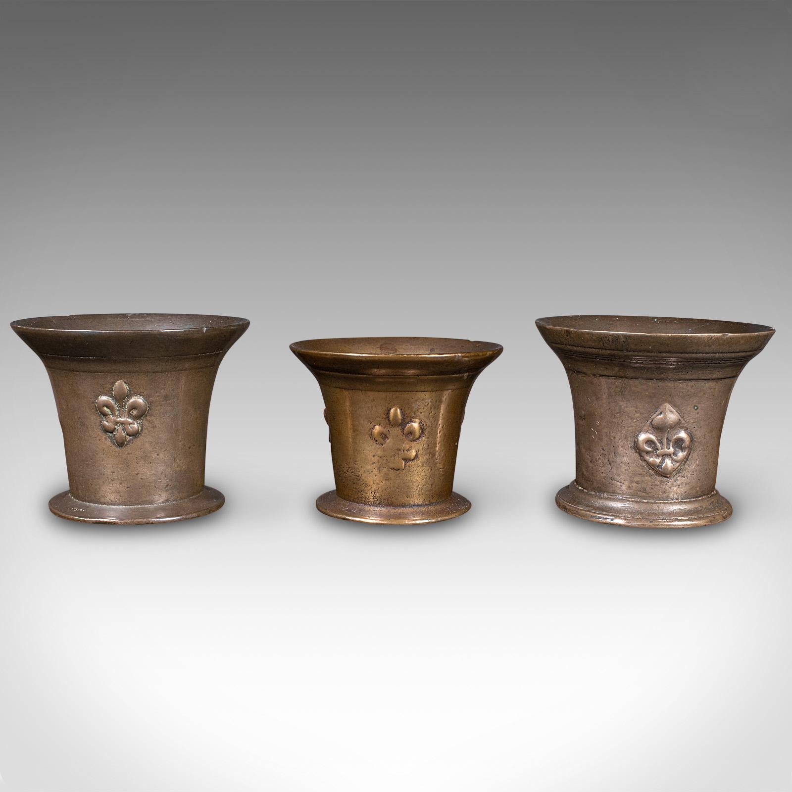 This is a trio of antique mortars. An English, bronze apothecary instrument, dating to the William III period, circa 1700.

Charming trio, ideal for decorative display or as planting pots
Displaying a desirable aged patina and in good original