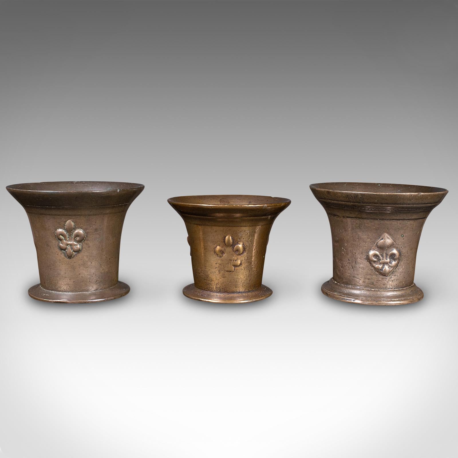 Il s'agit d'un trio de mortiers anciens. Instrument d'apothicaire anglais en bronze, datant de la période William III, vers 1700.

Charmant Trio, idéal pour une présentation décorative ou comme pots de plantation
Présentant une patine d'usage