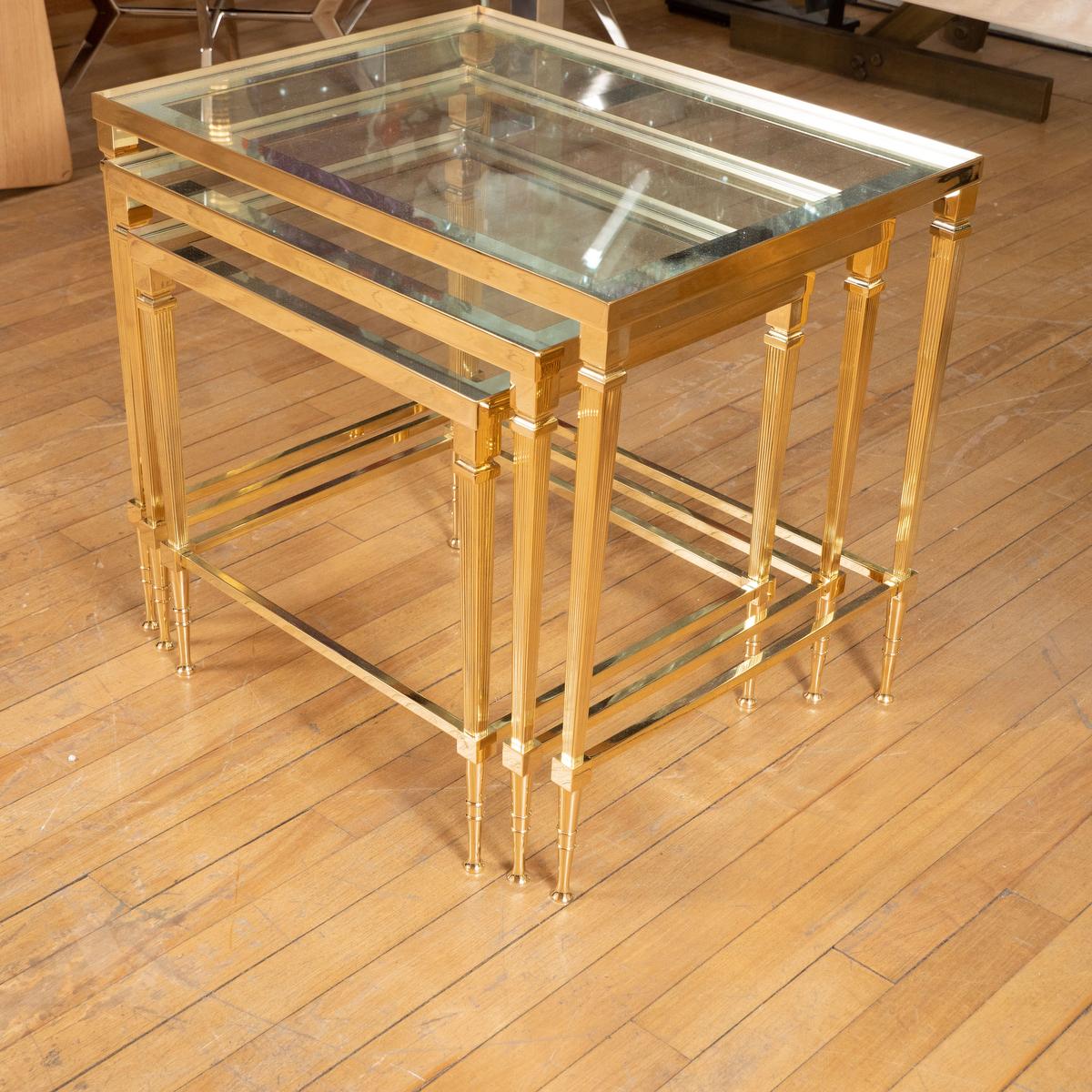 Trio of brass and glass nesting tables with decorative glass tops.