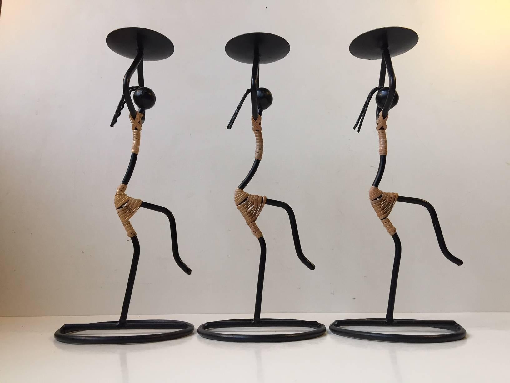 Decorative and sculptural trio of candleholders for bloc or ball candles. Designed and manufactured by Laurids Lonborg in Denmark during the 1960s. Composed of blackened string iron and rattan. The price is for the set of three.