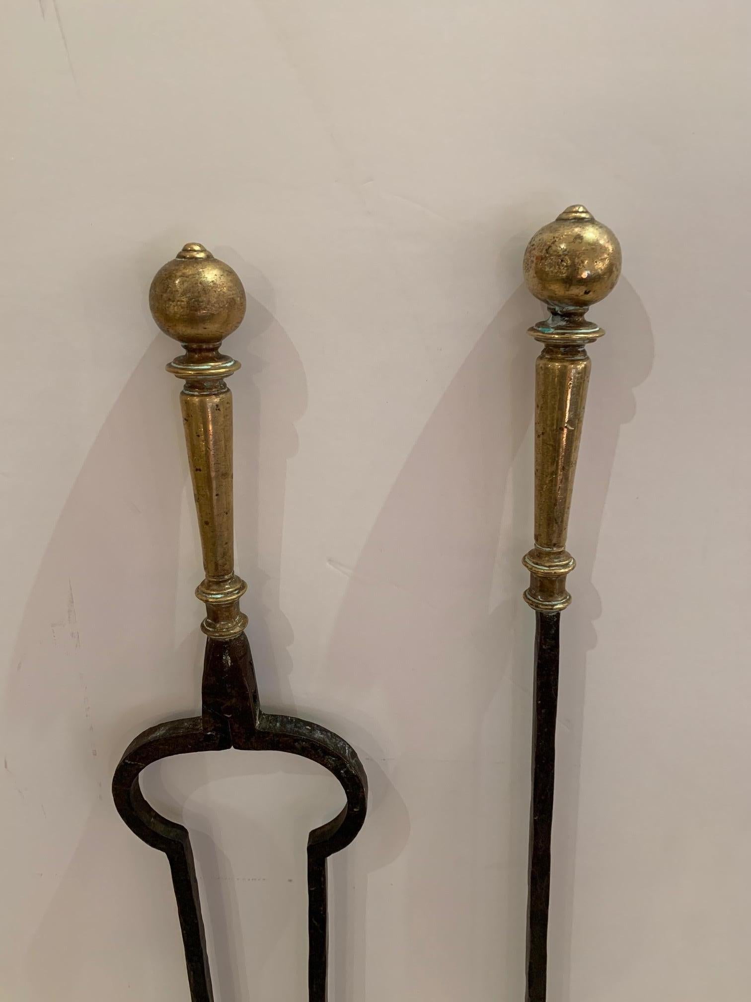 A handsome set of black hand forged iron fireplace tools with brass handles.
Measures: Fork 32.75” H x 4.25” W x 2” D
Tongs 32” H x 4.75” W x 2.5” D
Brush 26.75” H x 3” W 2.5” D.
 