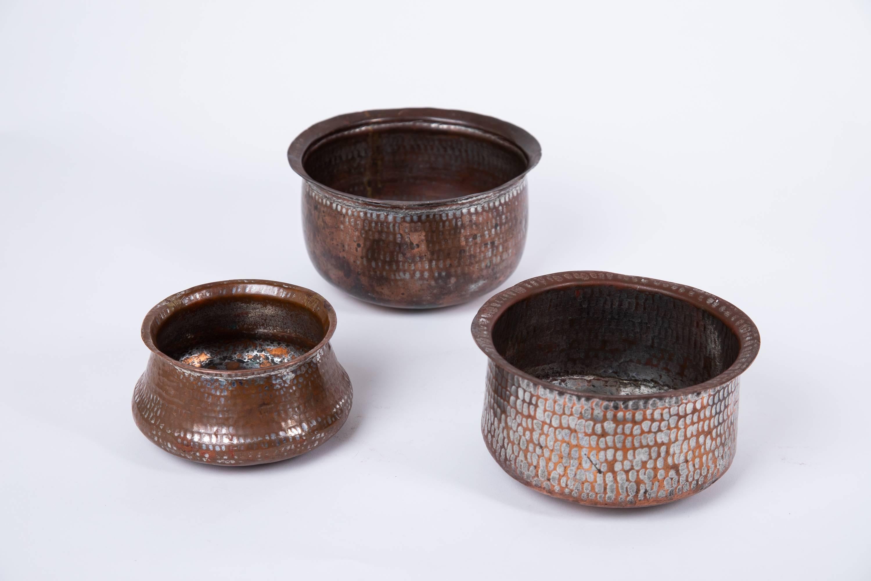  Set of three Indian hand wrought copper vessels.
 The metal wash over copper highlights the hammered vessels beautifully.
 Each vessel has a unique size. They measure from large to small:
 3.8