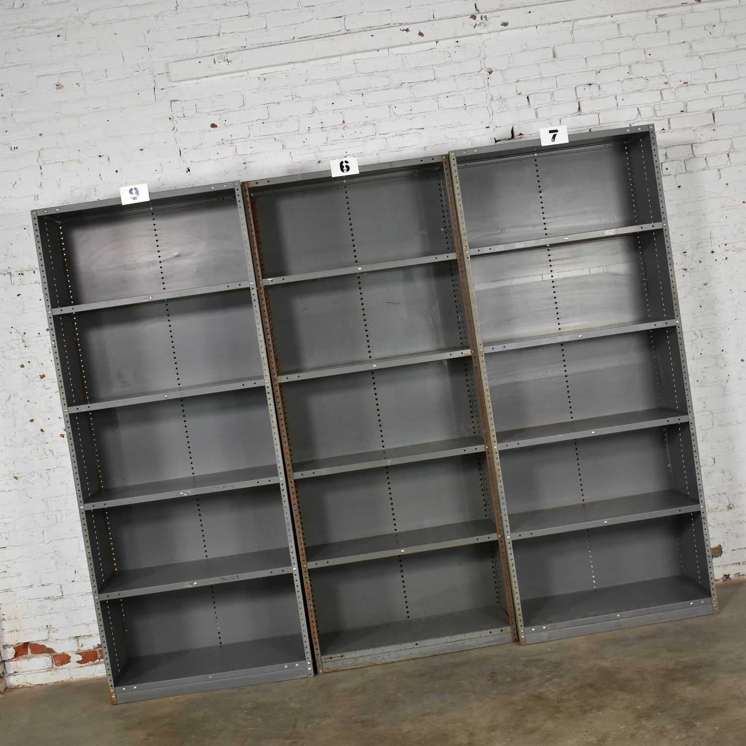 Awesome vintage industrial steel bookcase or shelving units. They are painted an industrial gray / green and have great age patina. All are in solid sturdy condition, but each have their own personality of dings, dents, rust and bare spots that