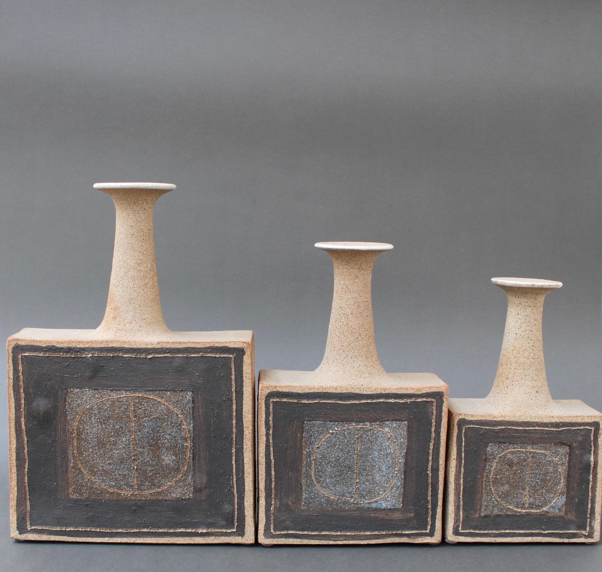 A trio of bottle-shaped vases by Italian ceramicist Bruno Gambone, (circa 1990s). These elegantly shaped narrow-opening flower vases are earthenware elevated to works of art. They are modern square bases with lean necks seemingly however, with