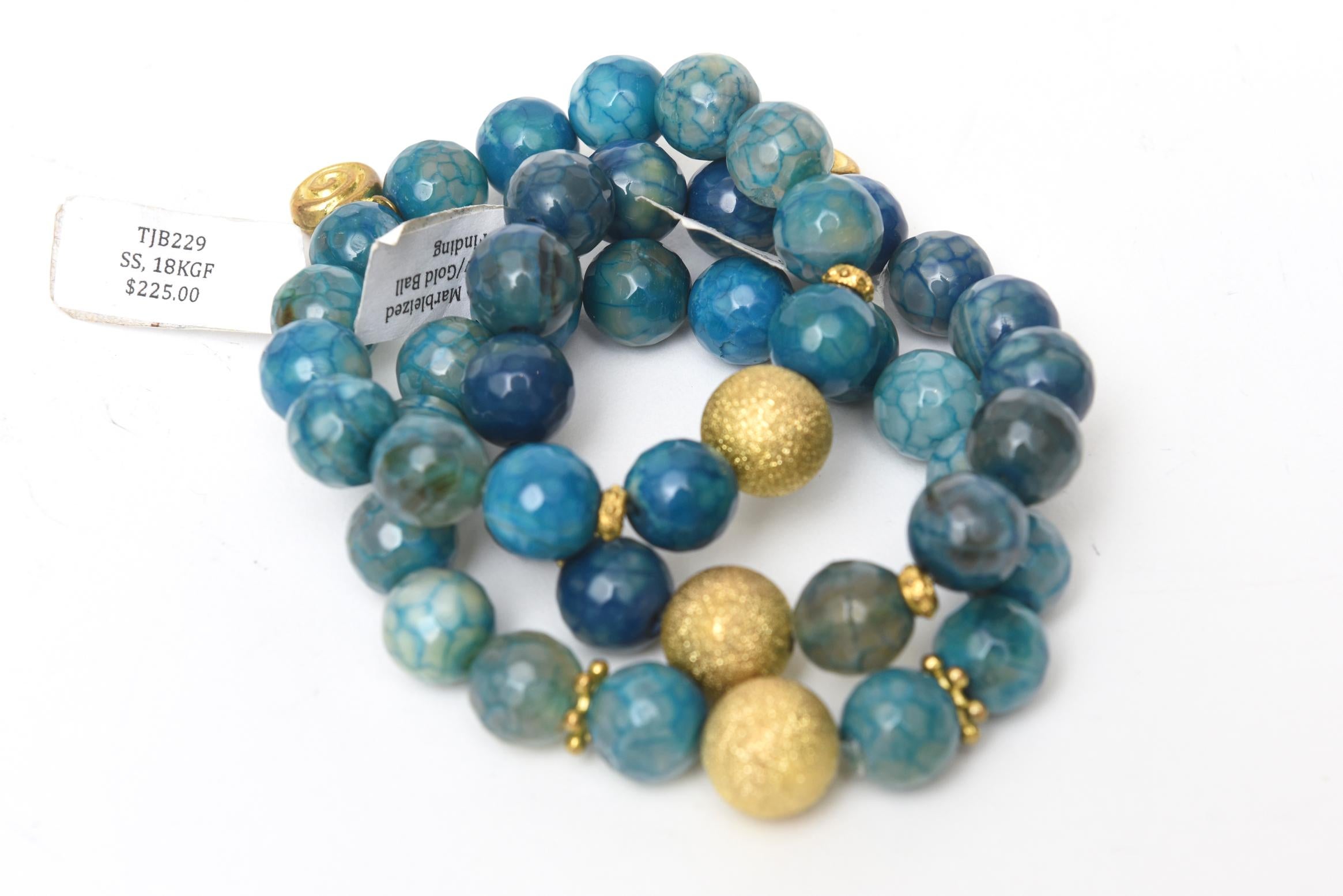 This trio of custom jeweler made stretch beaded bracelets are a combination of sky blue marbleized agate and blue lace agate mixed in with gold ball findings and other gold filled elements. They are a gorgeous hue of sapphire blue with hints of dark