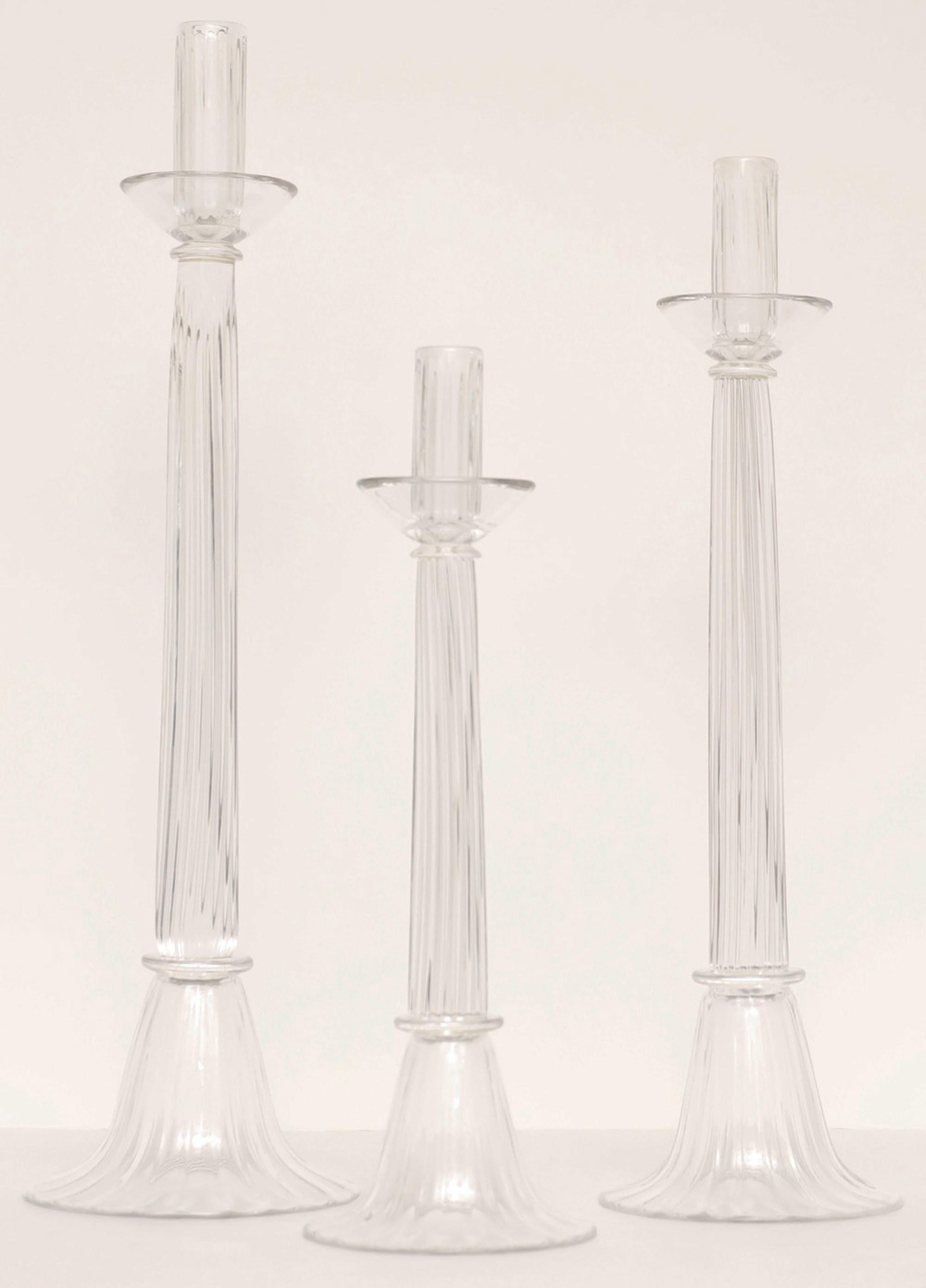 A trio of clear Murano glass candle stick holders by Luigi Mellara
Each one is hand blown with artist's signature engraved in the base.
Perfect in any setting ...

Elegant and simple !

Measurements below in additional comments.