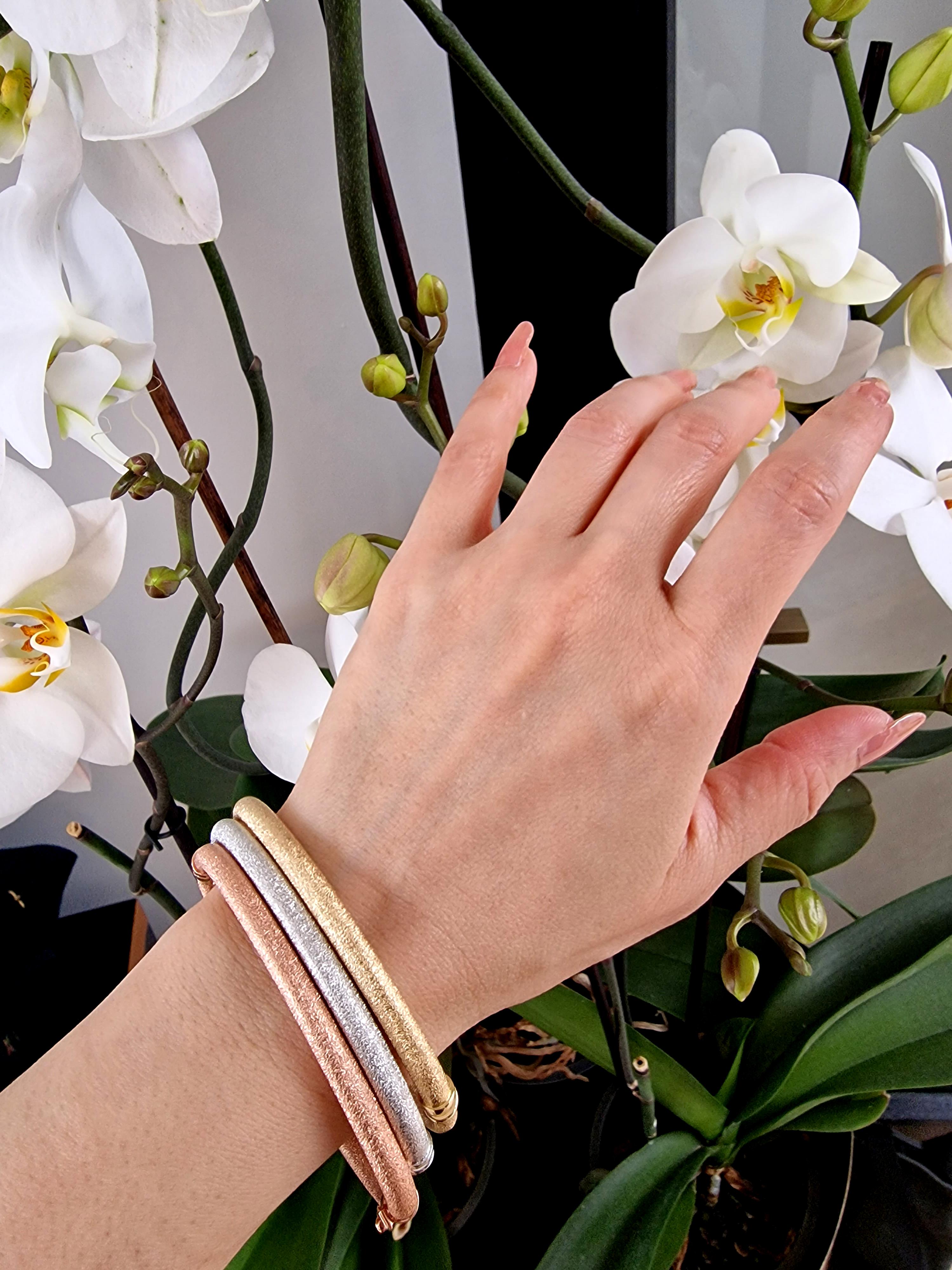 Trío de brazaletes a juego en oro amarillo, rosa y blanco de 18 ct.

Con un acabado mate fino y texturizado, con bisagra pulida y detalle de cierre -  Cada brazalete tiene un cierre de seguridad. Precioso por sí solo y perfecto para apilar hasta