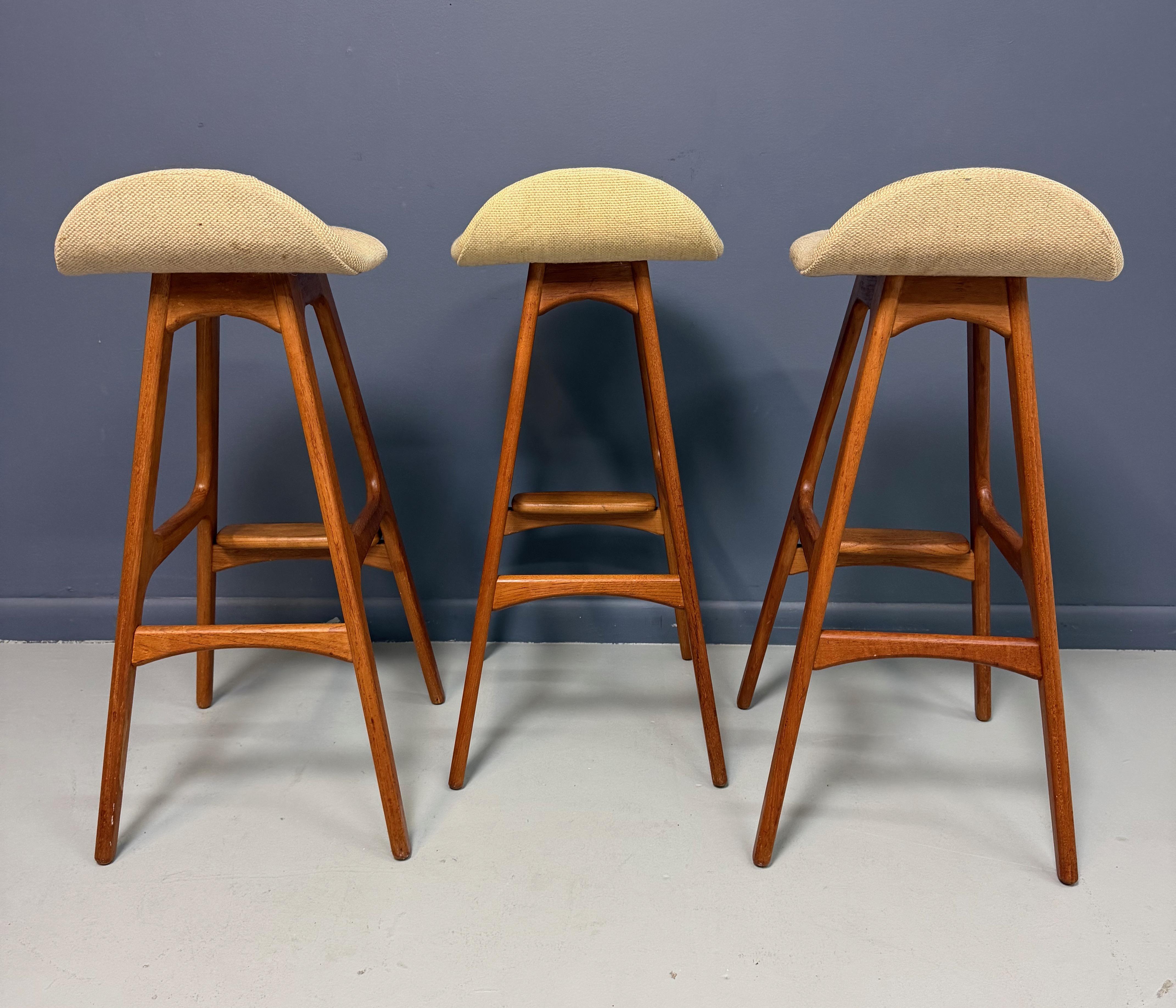 This elegant trio of mid-century bar stools, designed by Danish furniture maker Eric Buch, showcases the sculptural refinement and ergonomic sensibility that define his work. Crafted in rich solid teak, each stool features Buch’s signature organic