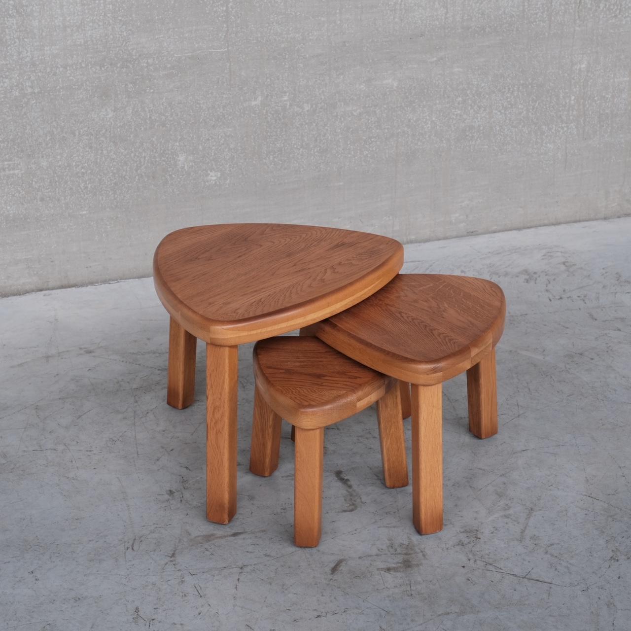A set of solid blonde oak nesting tables. 

Echoes of Chapo's T23 table shape. 

France, c1970s. 

Useful, stylish and functional. 

Can be used in a nest, or set around the room as side tables. 

Dimensions for the largest table.