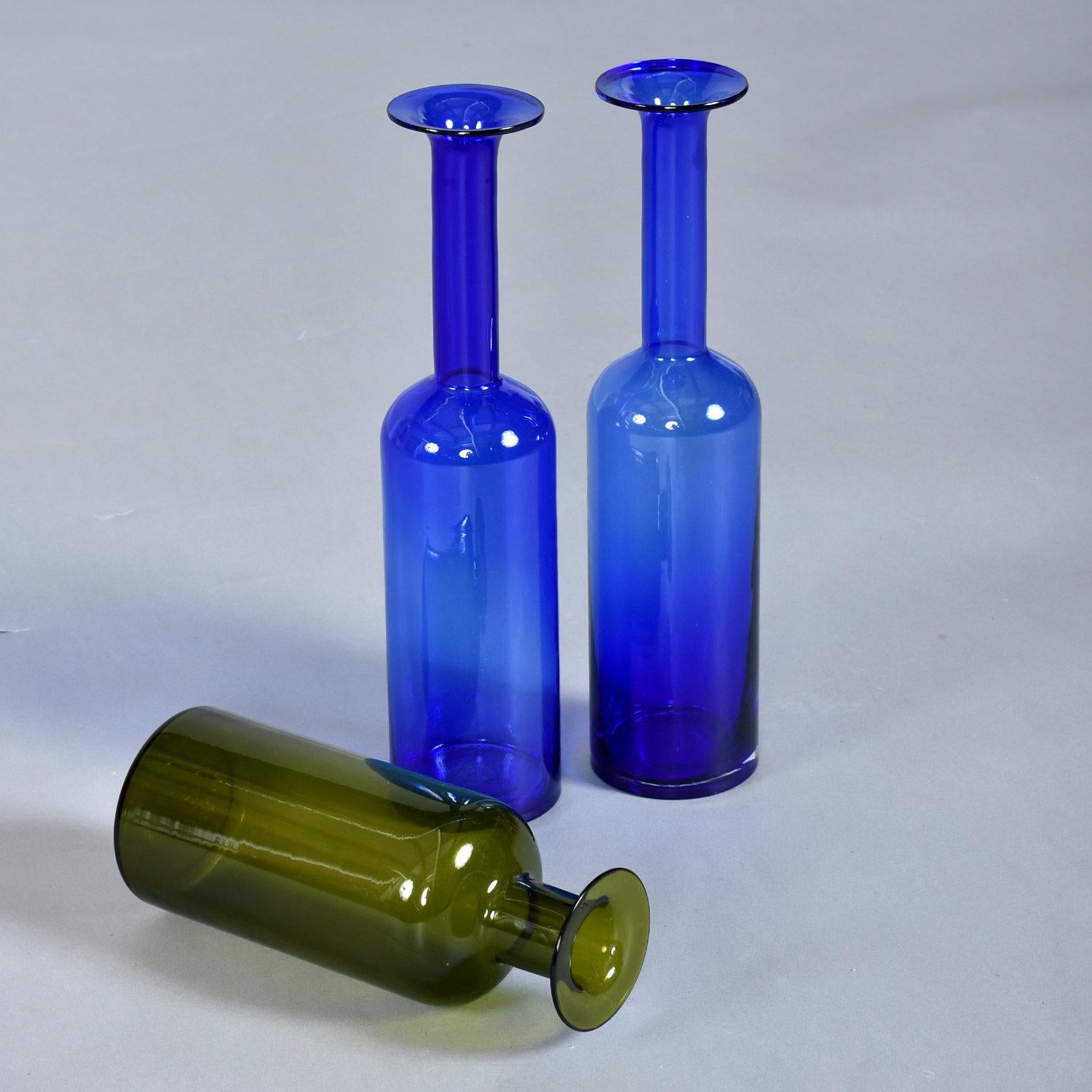 Trio of Gulvvase glass vases designed by Otto Brauer for Holmgaard. This set includes a pair of 17 inch tall blue vases and one green vase at 11.75 inch high. The iconic bottle shaped vases were designed in the 1960s and remain desirable amongst