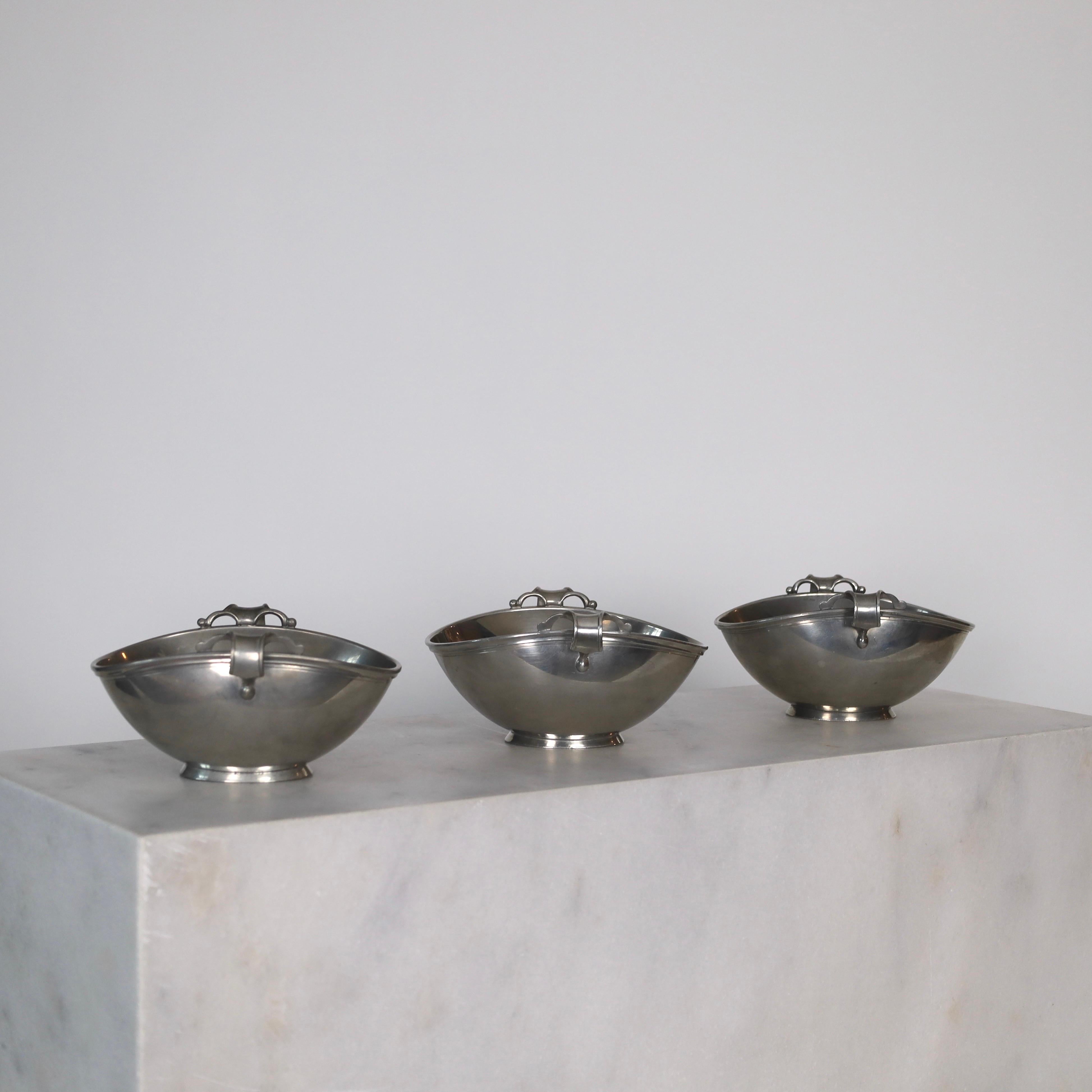 Pedestal Pewter Bowls made by Just Andersen in 1939. An elegant trio for a beautiful space.

* Three (3) oval pewter bowls on foot  
* Designer: Just Andersen
* Model: 2153
* Year: 1939
* Condition: Good vintage condition. Makers engraving intact.