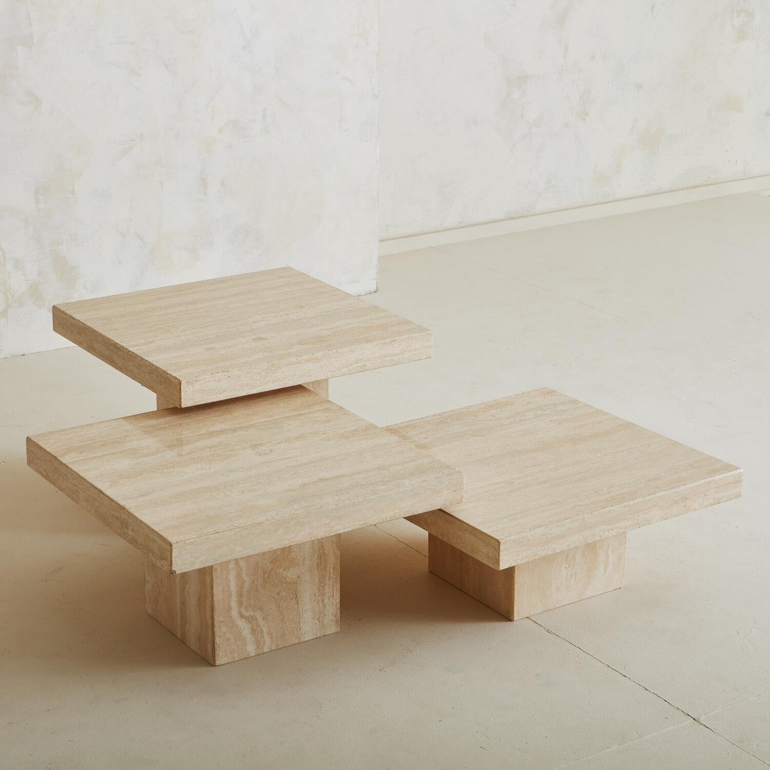 A trio of honed travertine coffee tables with square table tops and bases. Group them together as a coffee table, or spread them out as side tables. The varying heights allow them to be arranged in any configuration desired. These tables feature