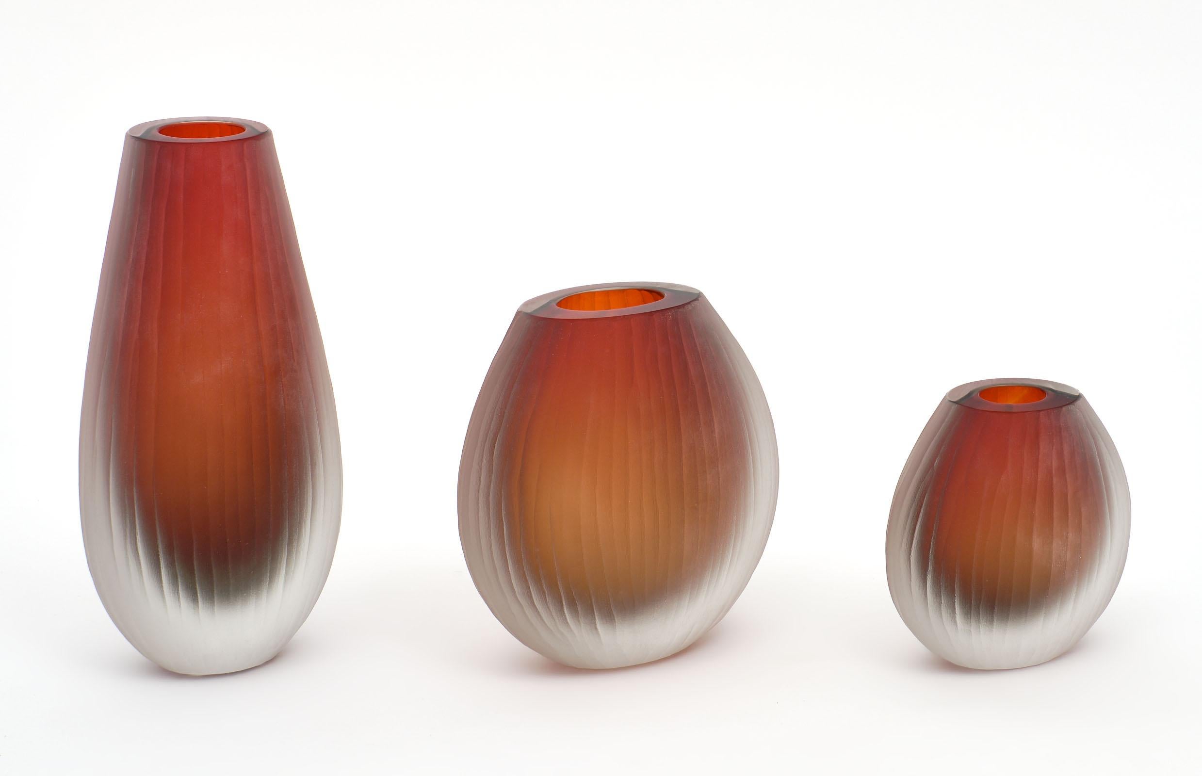 Three hand blown Murano glass vases of different sizes executed in the “battuto” or “hammered” fashion originated by Tobia Scarpa during his time at Venini. Each has a lightly textured and frosted finish with a beautiful ombré tone of red to orange.