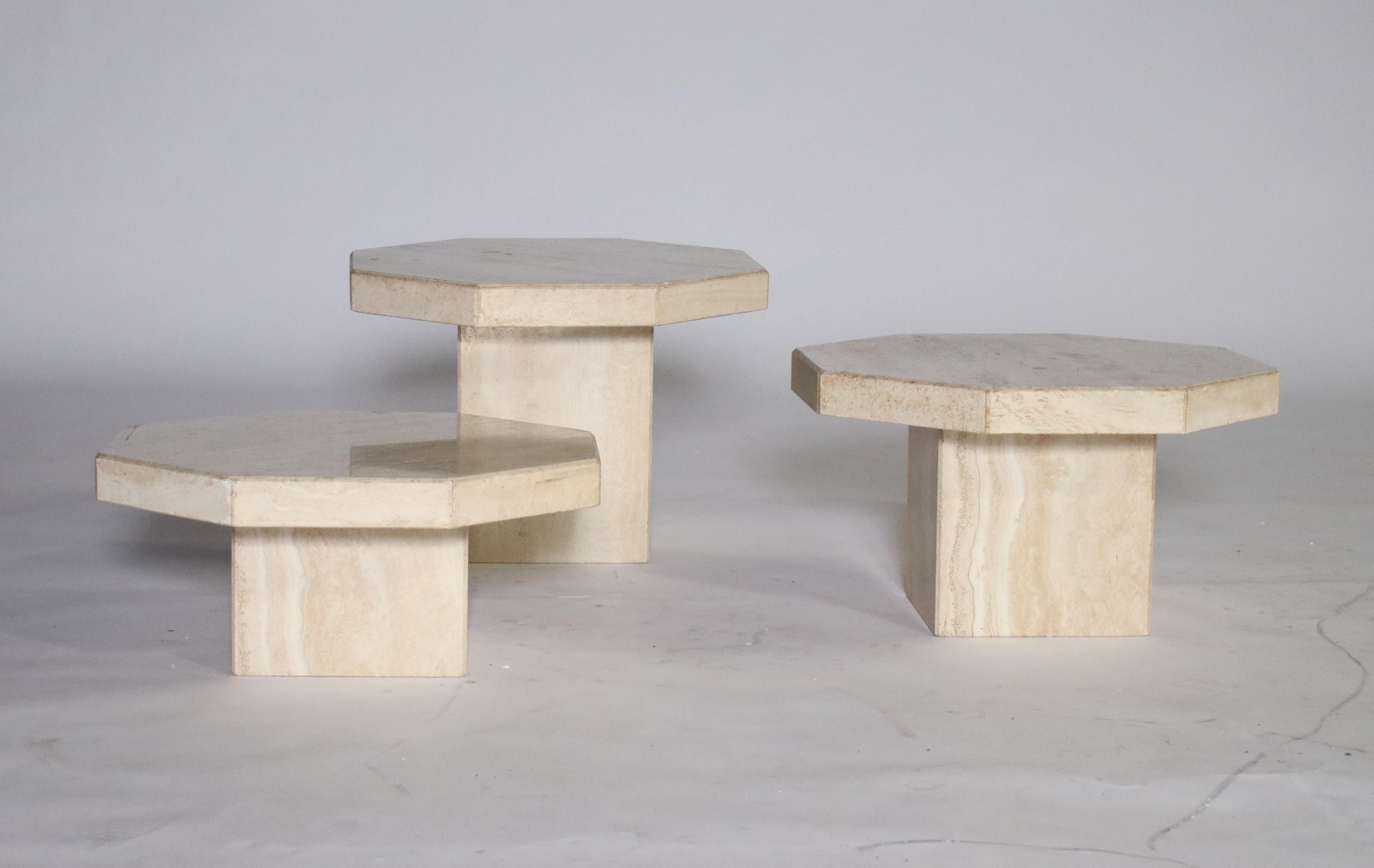 1970s trio of Travertine tables in various heights and removable hexagon-shape tops. Can be used as a cluster of cocktail tables or separate end tables. 
Largest 20.5