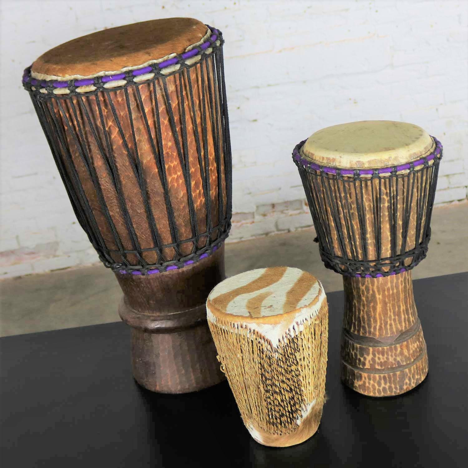 Intriguant trio de tambours tribaux de tailles différentes en bois sculpté et en peau d'animal. Ils sont en très bon état. Le prix est fixé pour un ensemble. Vers le 20e siècle.

Nous sommes amoureux de ces tambours tribaux ici à la boutique !