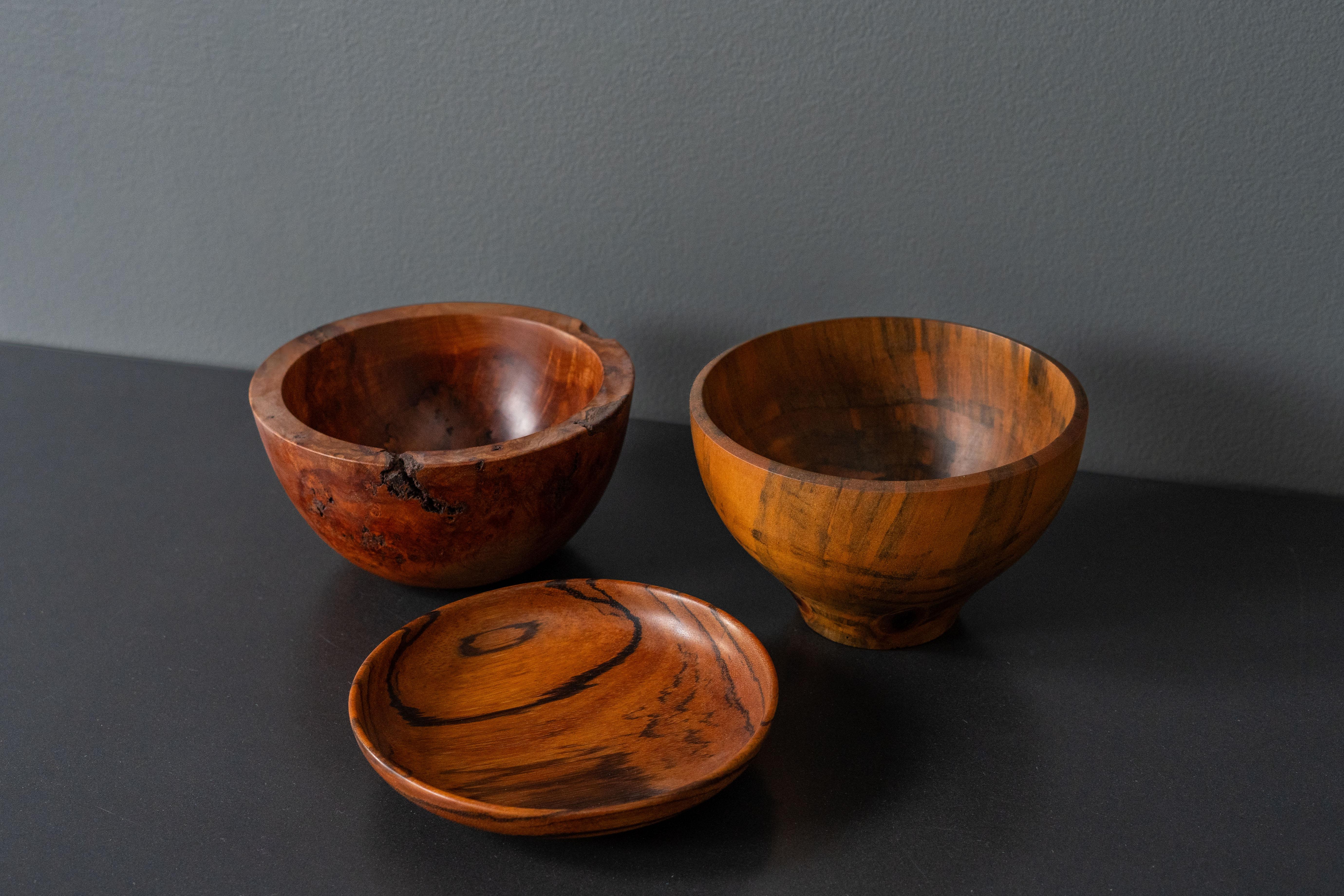 USA, ca. 1960s / 1970s. An attractive instant collection of three studio wood bowls. Each features a masterfully turned design executed in dramatically figured zebrawood, mesquite, and Norfolk pine. Strong examples by various American craftsmen