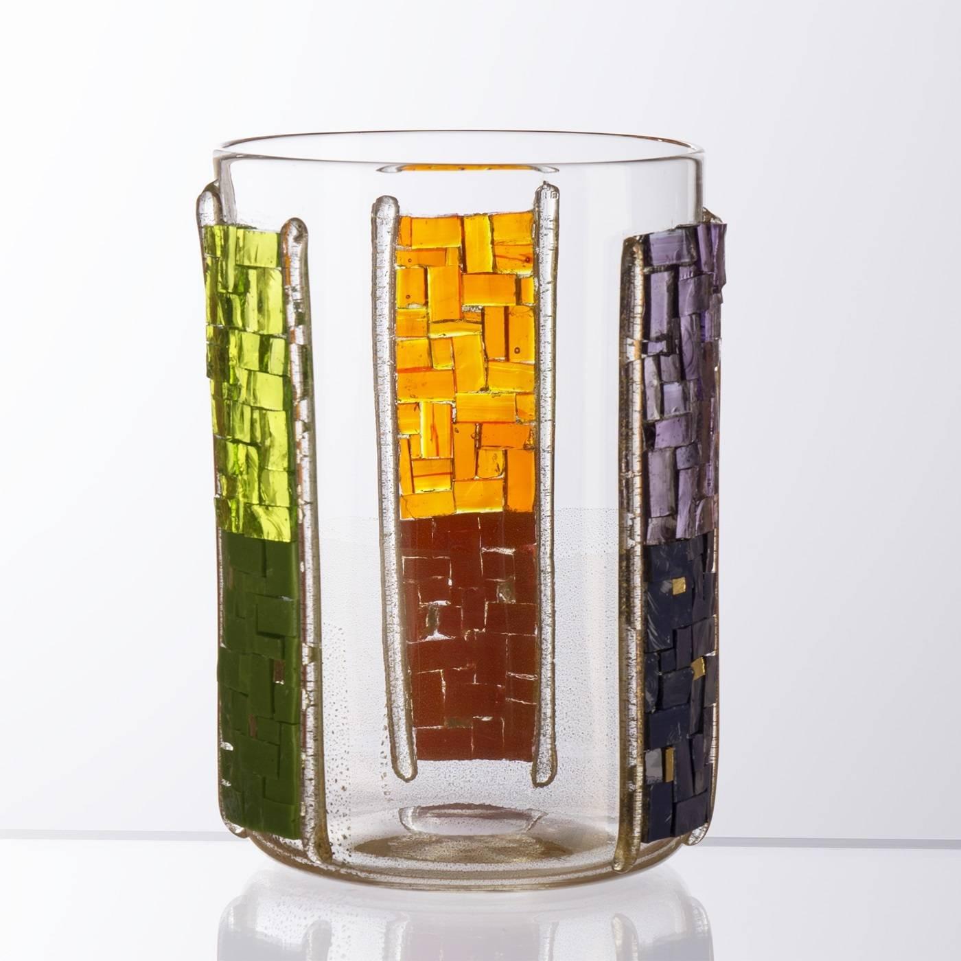 Part of the Tableware collection this colorful candle holder is made of Murano mouth-blown clear glass with three mosaic stripes in secondary colors: green, orange, and purple that have been applied 