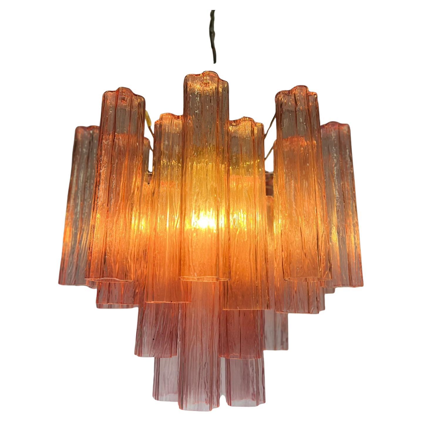 Trio di lampadari vintage italiani in vetro di Murano rosa e struttura in metallo nichelato. L'armatura in nichel lucido sostiene 30 grandi tubi in vetro dorato.
Dimensioni: 47,25 pollici (120 cm) di altezza con catena, 24,80 pollici (63 cm) di