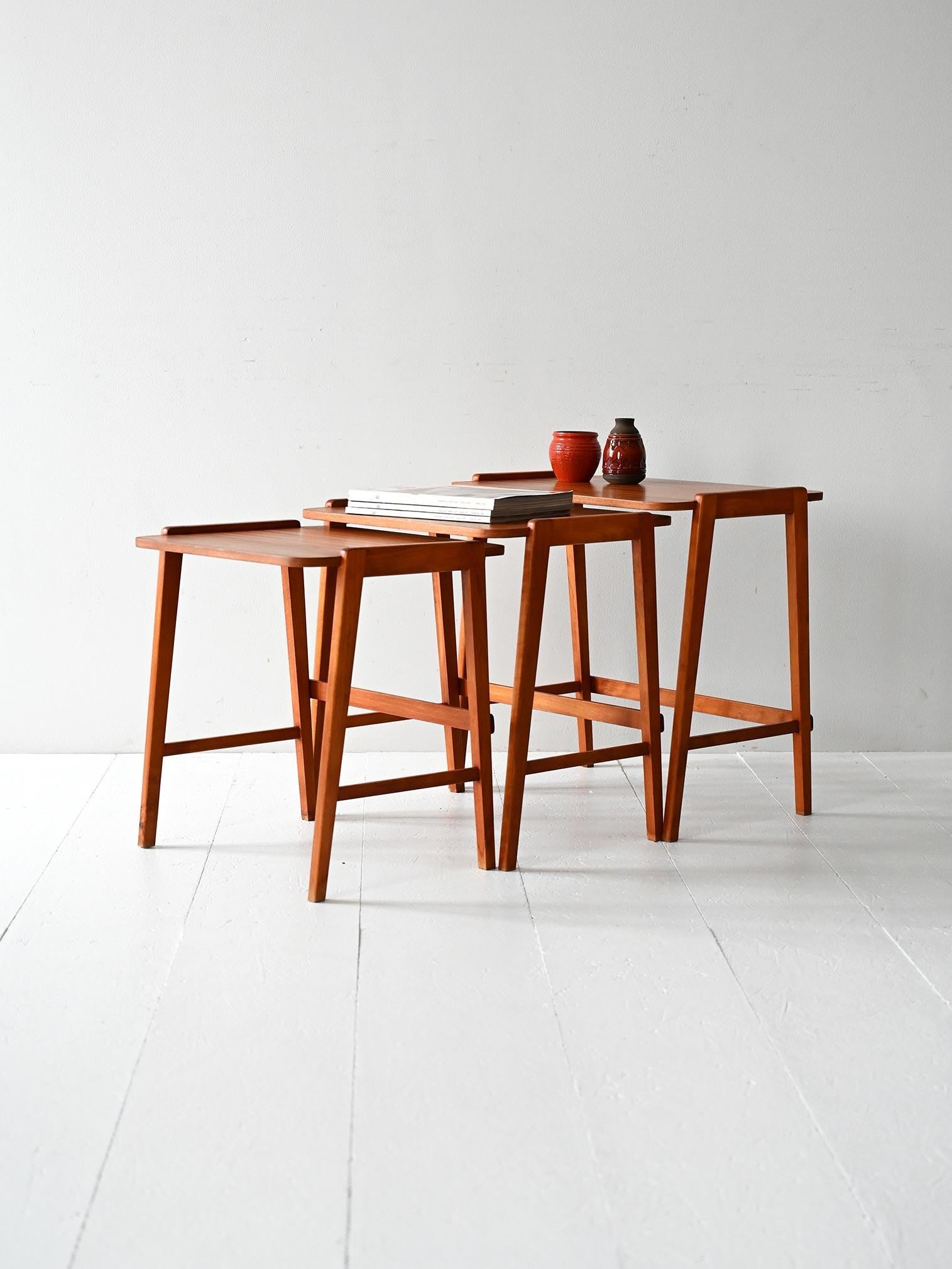 Set of three mahogany interlocking side-edge tables, Scandinavian production 1960s.

Trio of vintage Scandinavian interlocking coffee tables, made in the 1960s. Mahogany frame with rectangular top finished with a thin perimeter border. The design