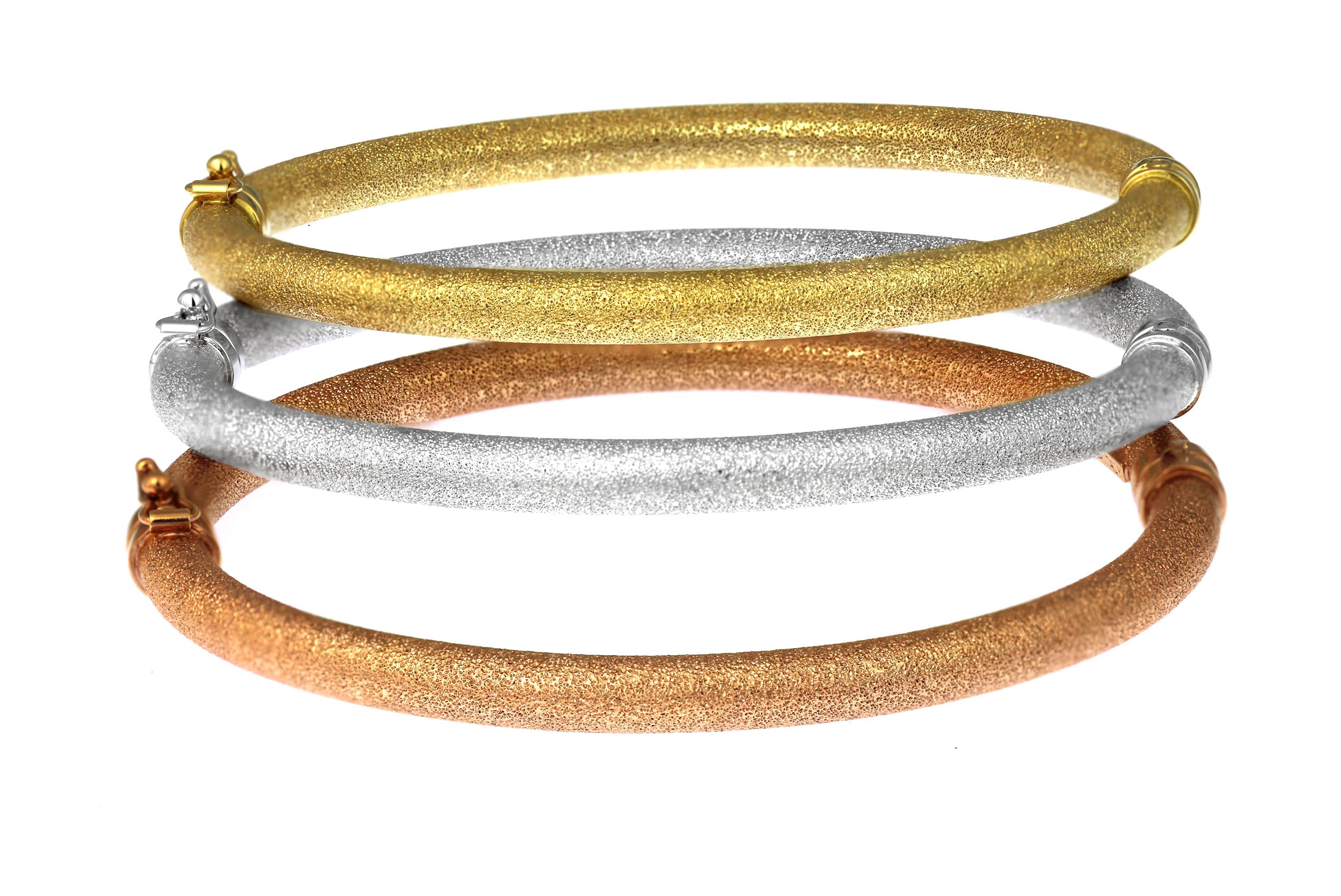Trio of matching bangles in 18ct yellow, rose and white gold.

Featuring a fine, textured matt finish with polished hinge and clasp detail -  each bangle features a safety clasp.

Each bangle is 5.0 mm in diameter.  
Internal length: 6.5 cm,