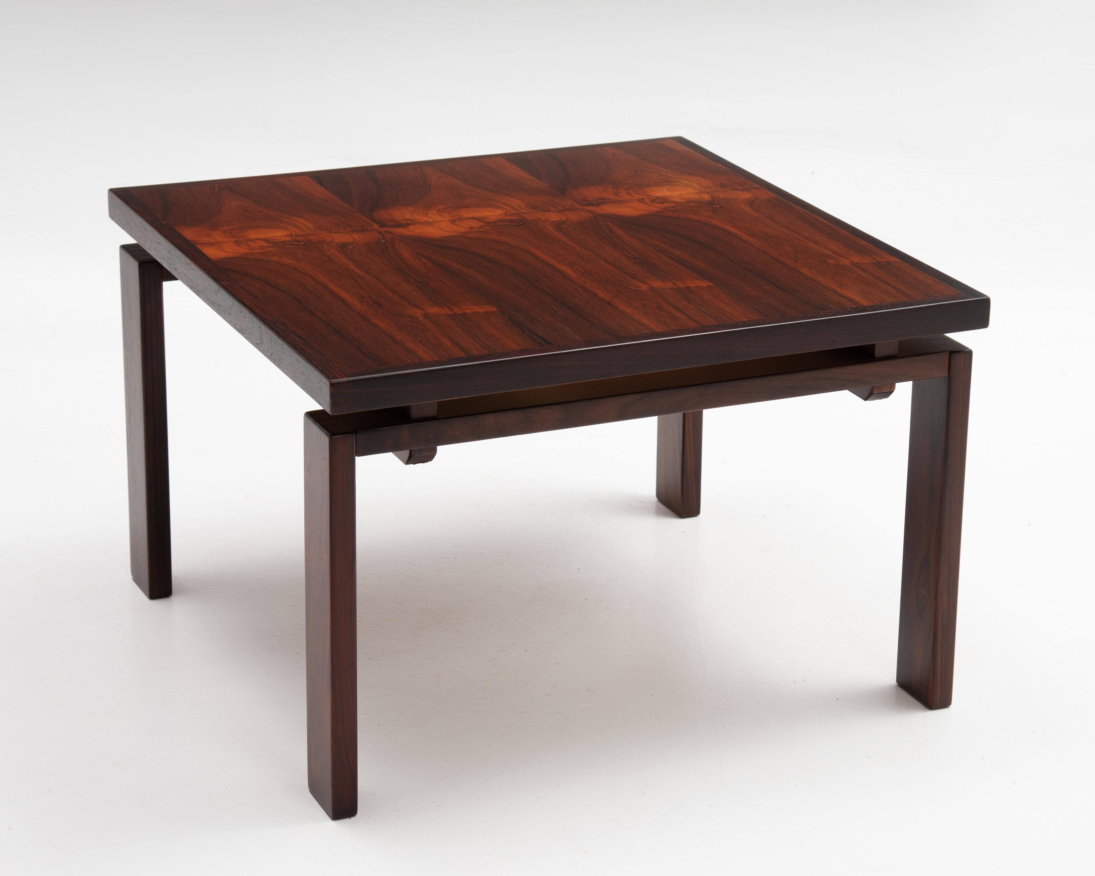 A very well made Danish rosewood floating top coffee table made by Trioh. This versatile table features solid rosewood and rosewood veneer. Square top. Excellent wood selection and joinery. Fully marked 