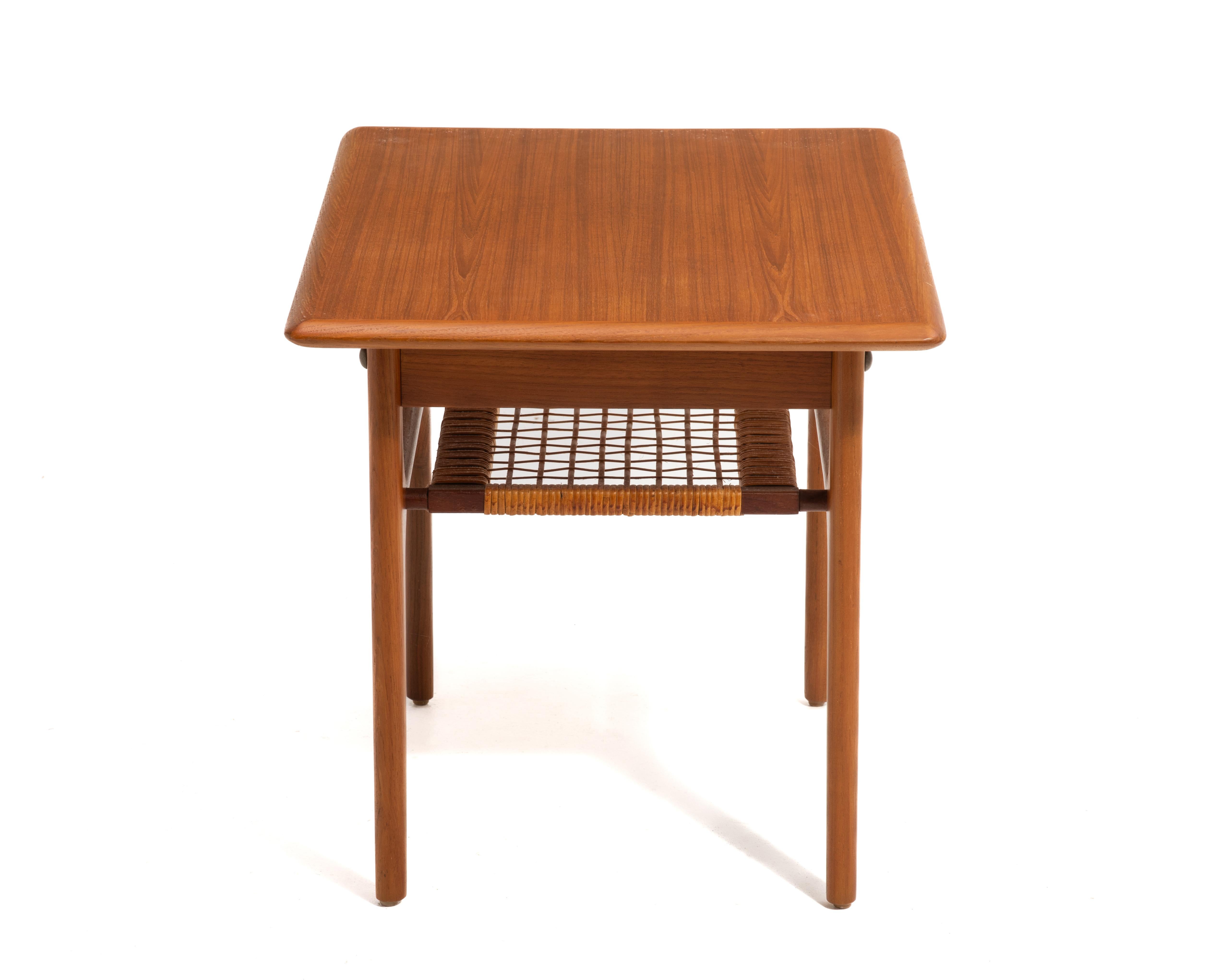A beautifully crafted Danish teak and cane table by Trioh Møbelfabrik, circa 1960s. The top has been professionally restored and the cane is original with a small, invisible repair.